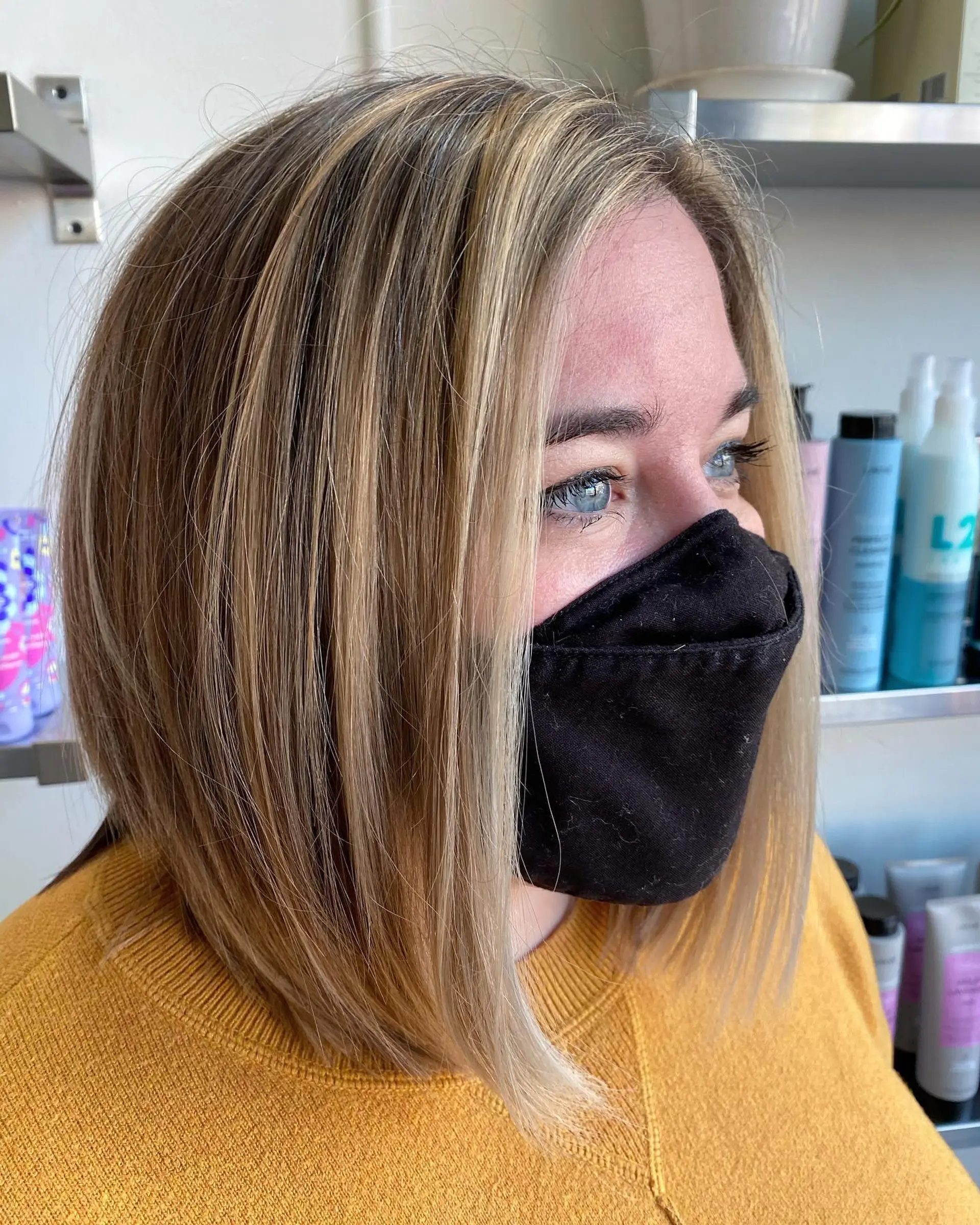 A sleek, straight angled lob featuring dimensional blonde highlights and face-framing brightness. 1