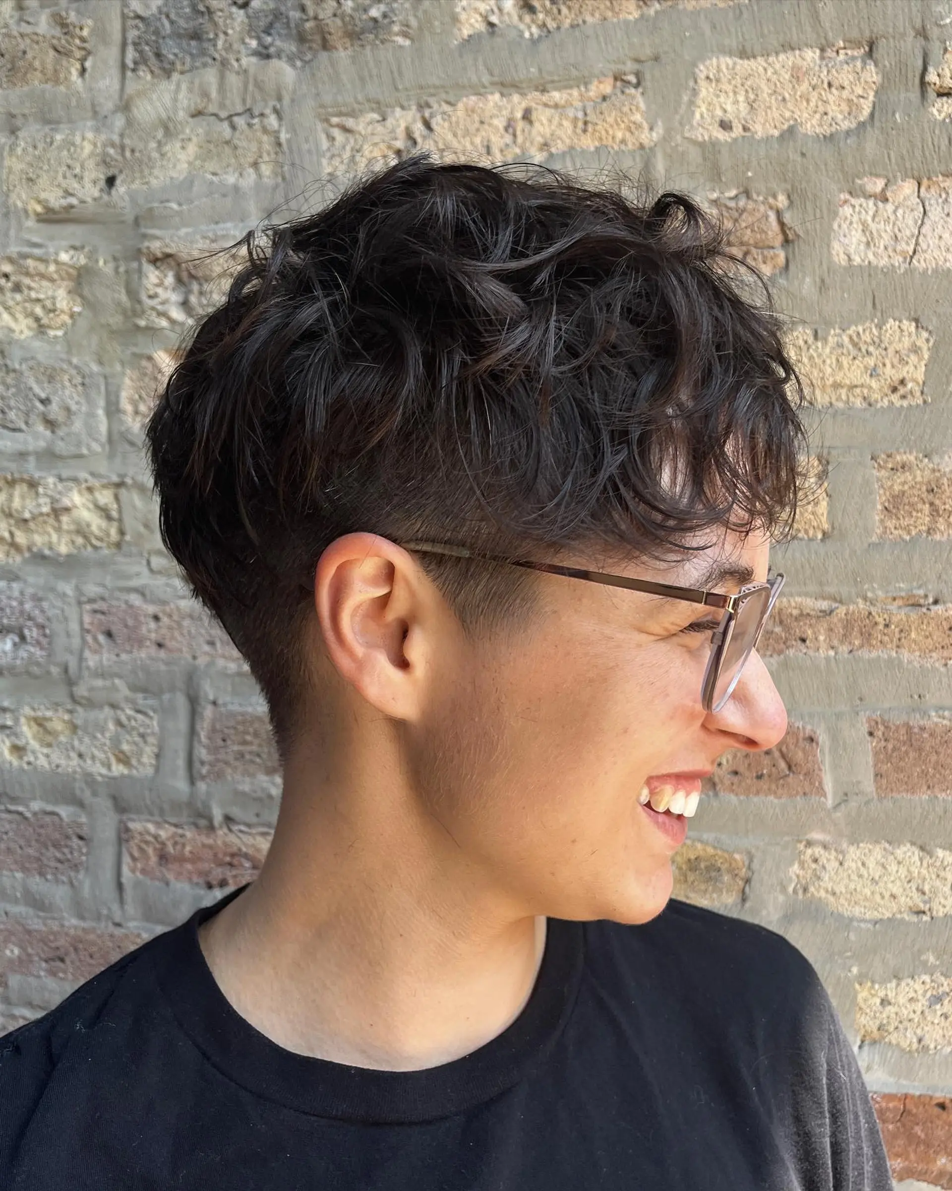 A short, textured crop with a taper fade, styled to enhance natural waves. 1