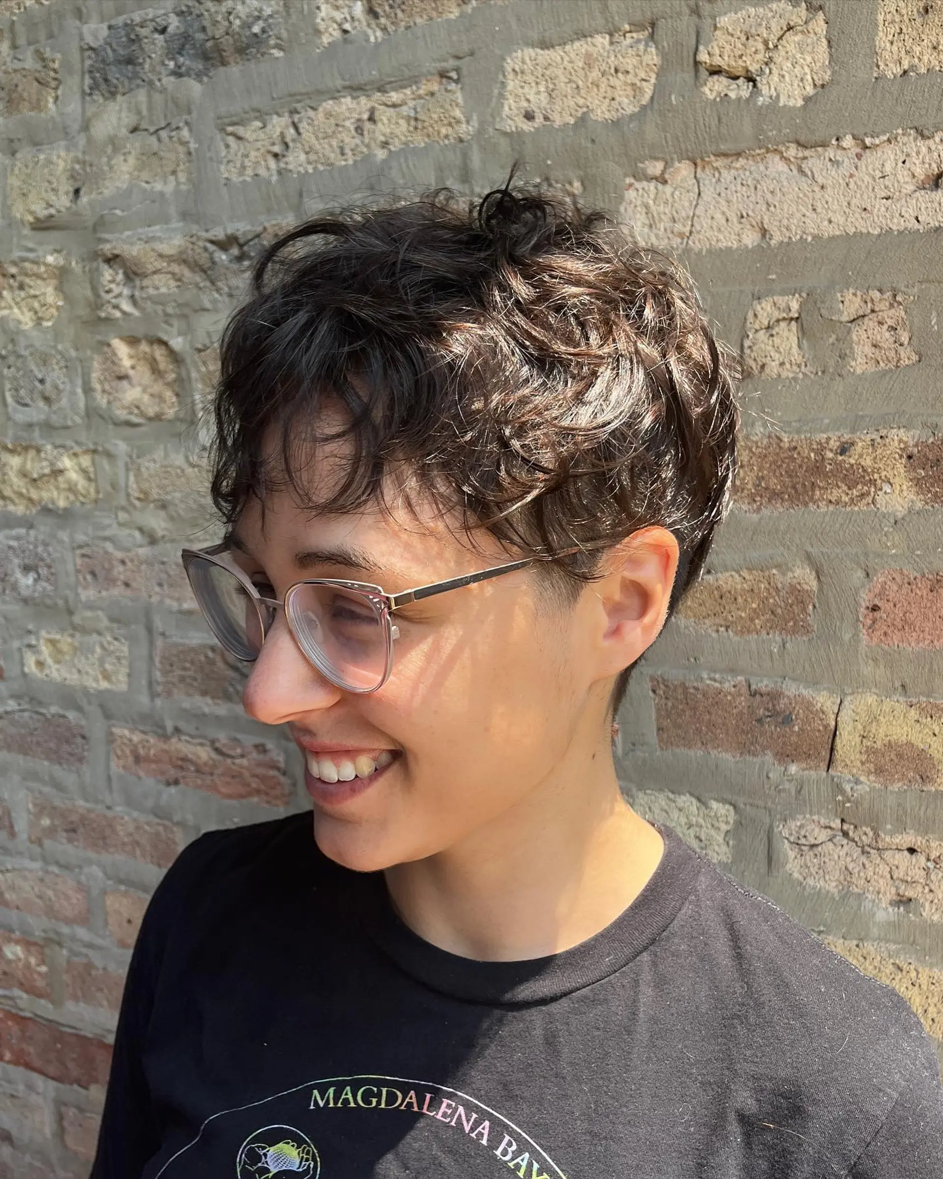 A short, textured crop with a taper fade, styled to enhance natural waves. 3