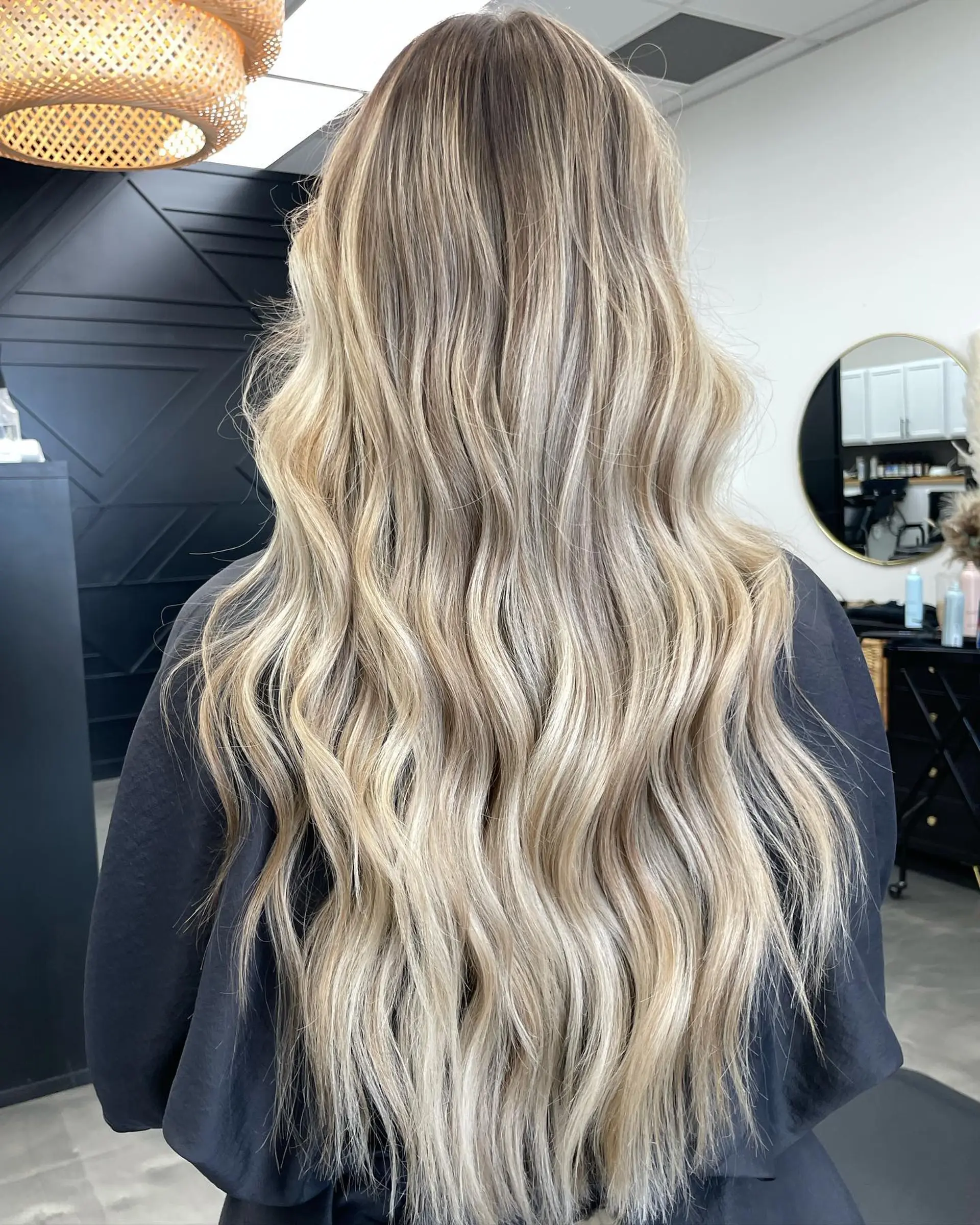 Long hair featuring a seamless sandy blonde balayage styled into loose, flowing waves. 1
