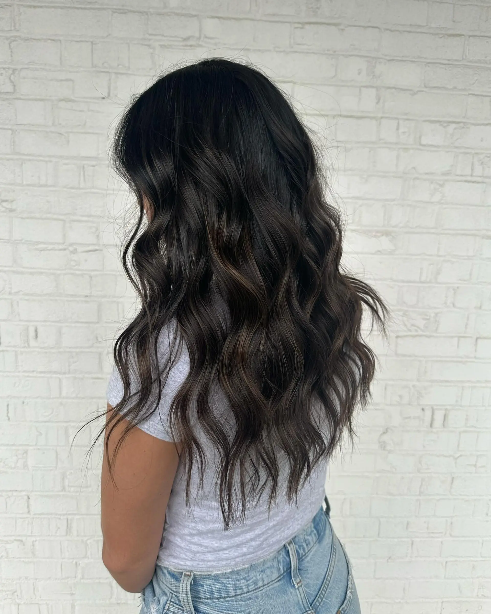 Long, flowing dark espresso brunette hair styled with loose, dimensional textured waves. 1