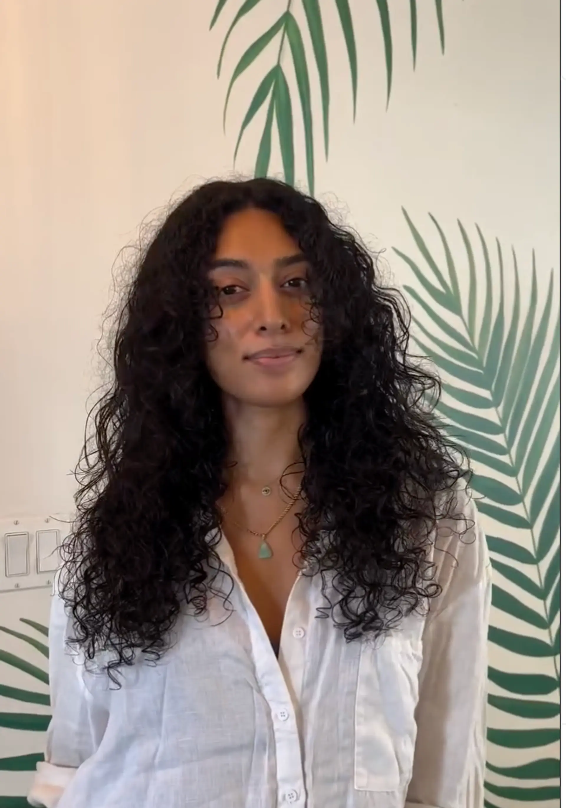 A long layered curly hairstyle with defined natural texture. 1