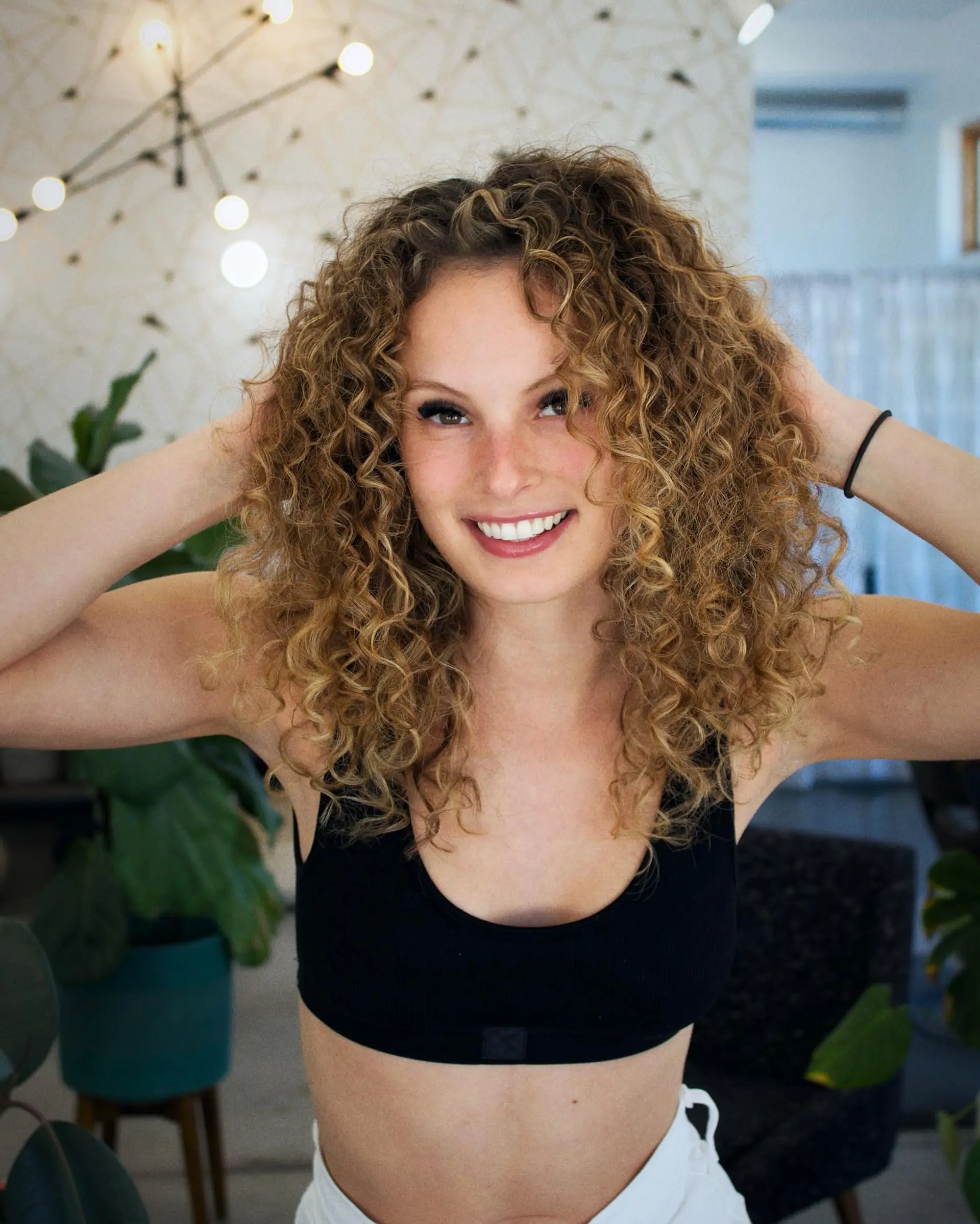 Defined, bouncy medium-length curls with dimensional golden highlights and plenty of volume. 1