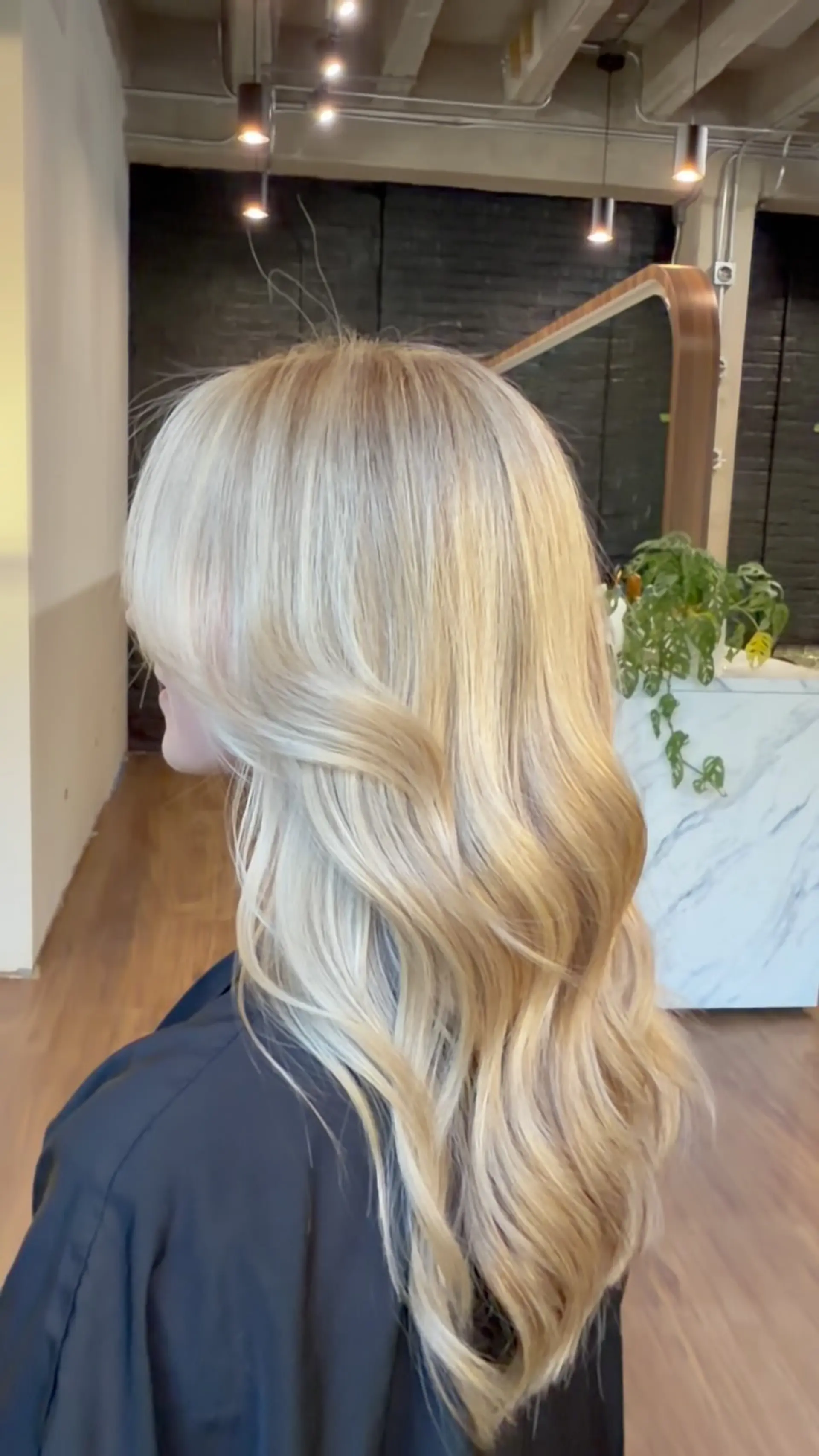Long bright blonde hair with subtle dimensional tones styled in smooth, loose cascading waves. 1