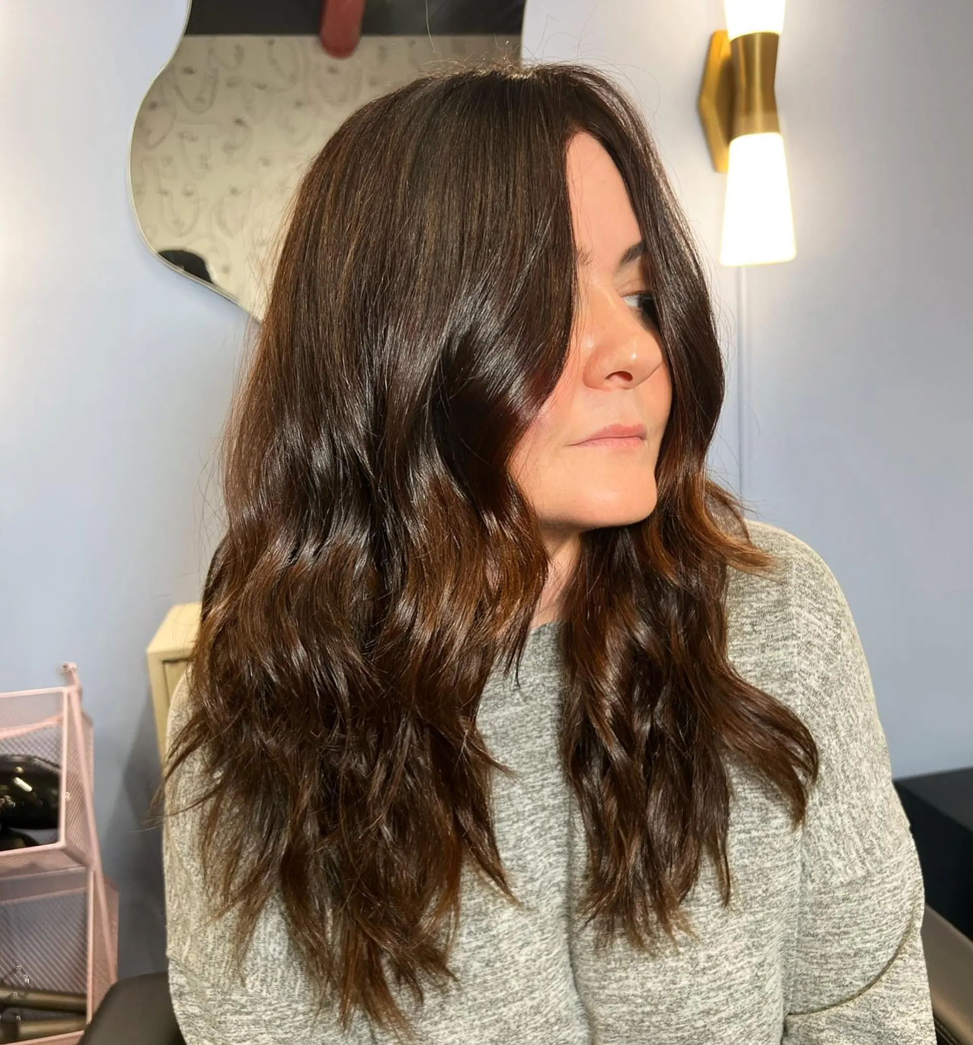 Long layered wavy hair with subtle bronzed highlights. 1