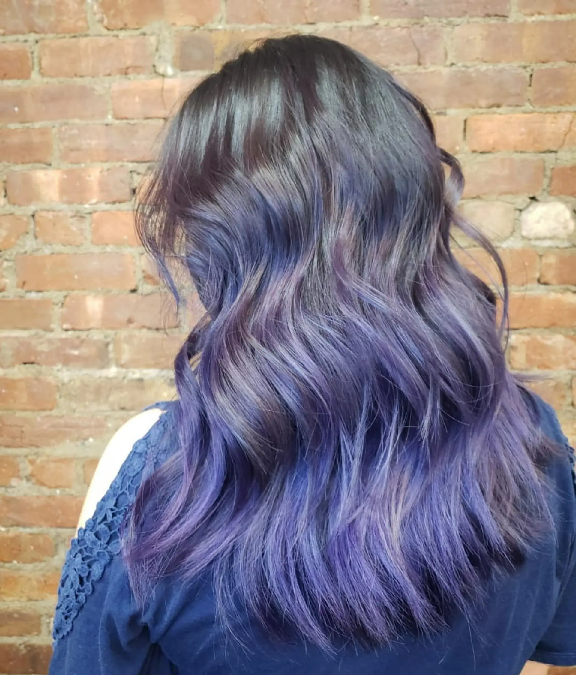Long wavy hairstyle featuring a seamless violet-blue balayage blending from dark roots into vibrant purple-indigo tones. 1