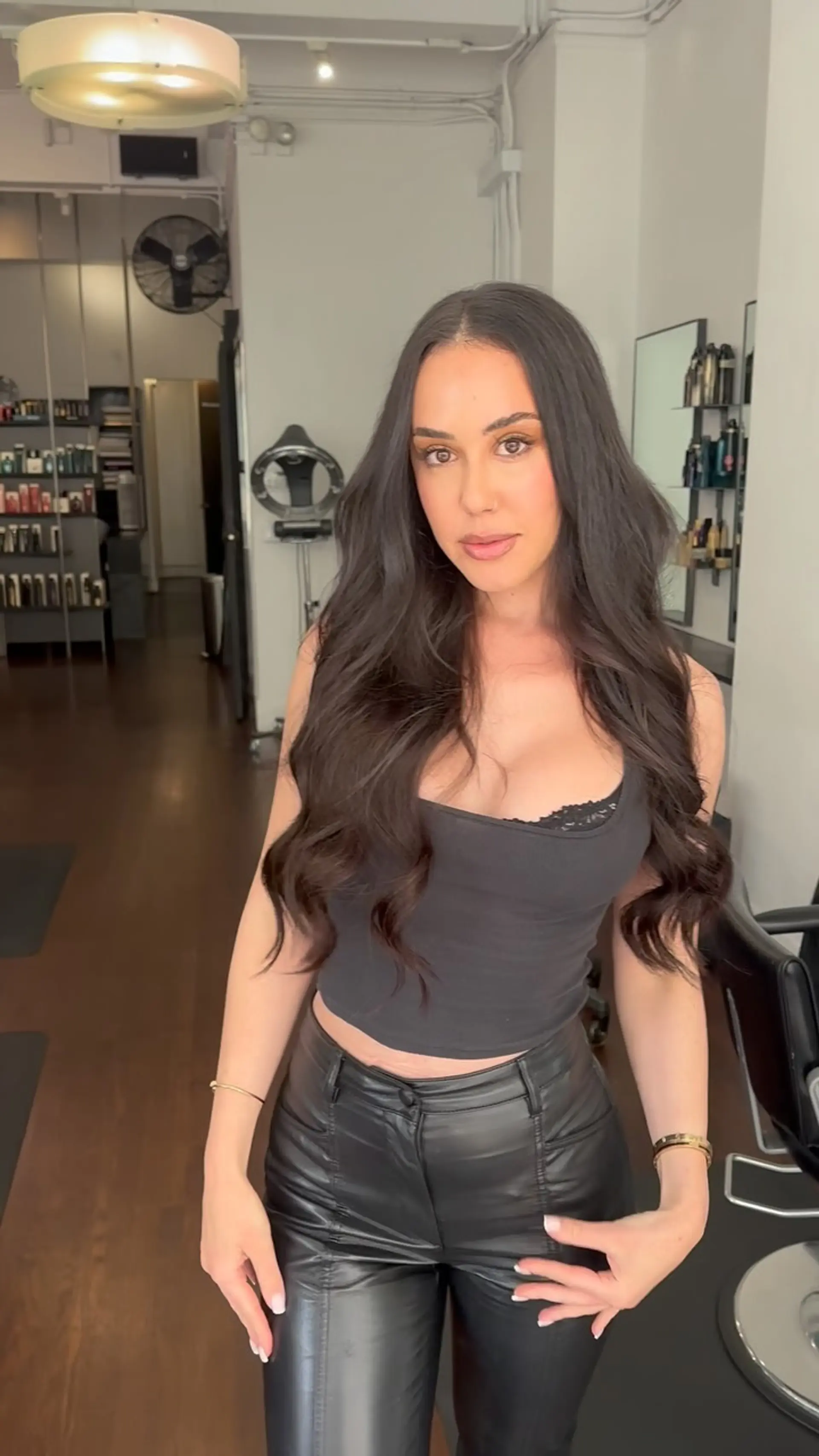 Long, flowing off-black hair styled with a center part and soft, loose waves. 1