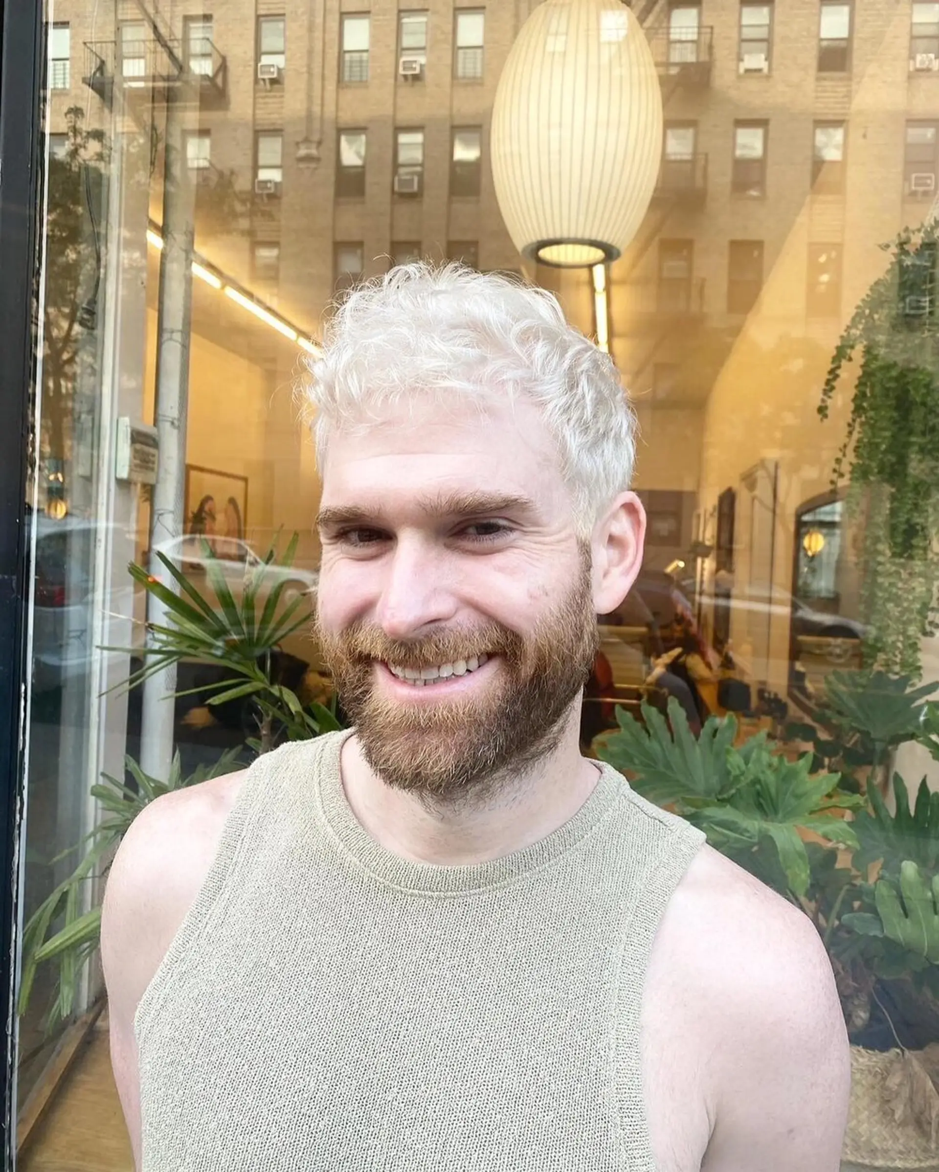 A short-length, platinum blonde hairstyle featuring soft waves with a textured fringe and close-cropped sides, blended into a contrasting natural beard. by @kotomiacacio__hair 1
