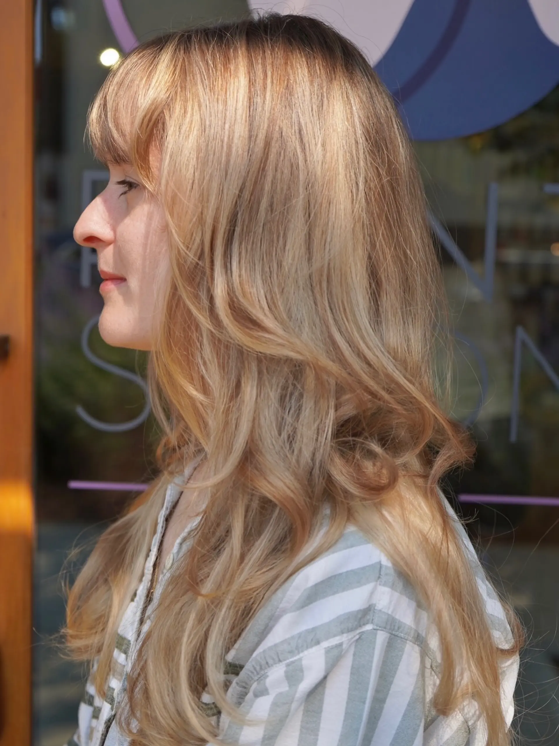 Long warm blonde hair with full fringe bangs and soft face-framing layers. 1