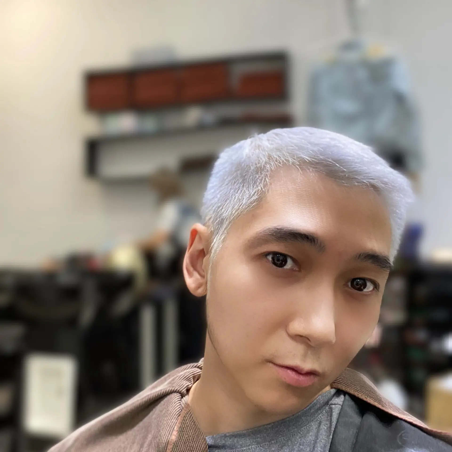 A very short buzz cut, bleached to a platinum blonde shade. 1