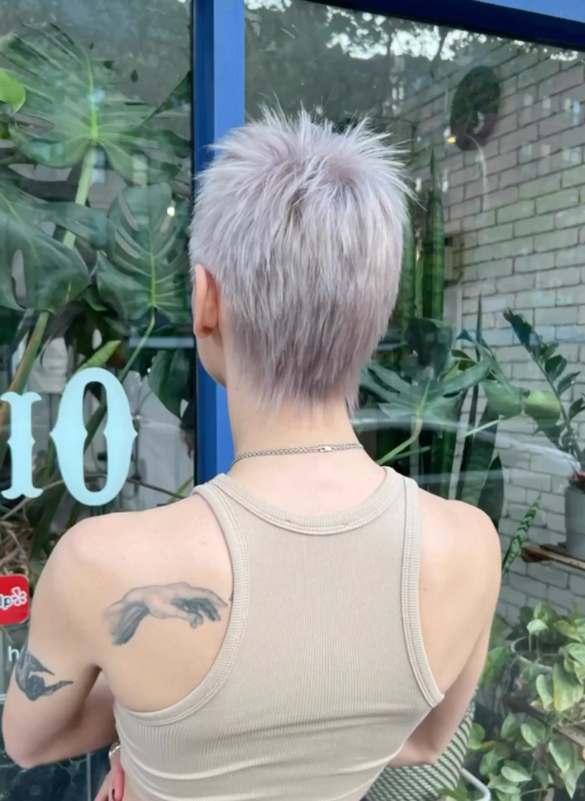 A very short, platinum blonde, and silver pixie cut with a textured fringe and tapered sides. 2