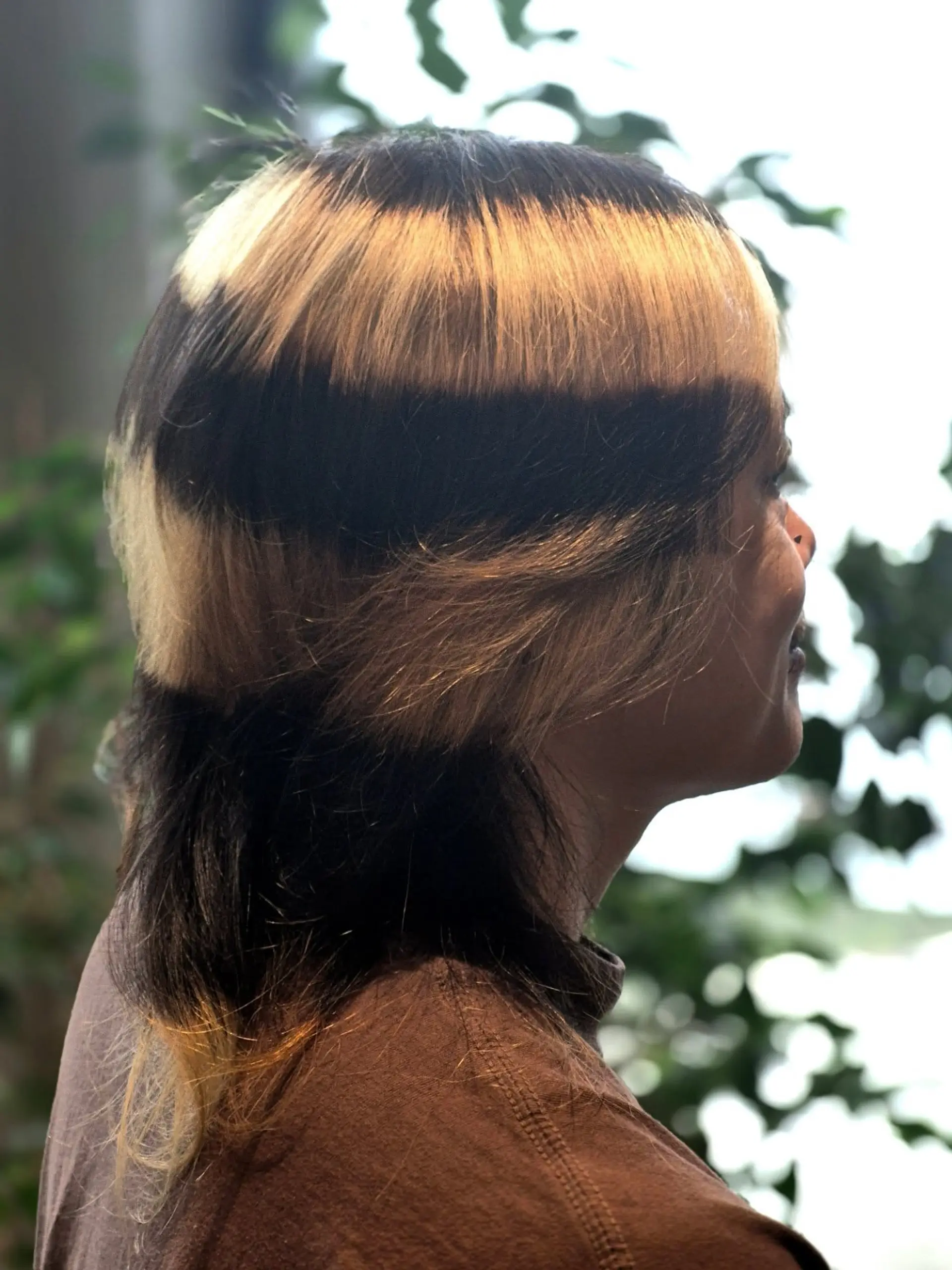 A layered mullet haircut featuring bold horizontal alternating stripes of black and warm blonde color. 1