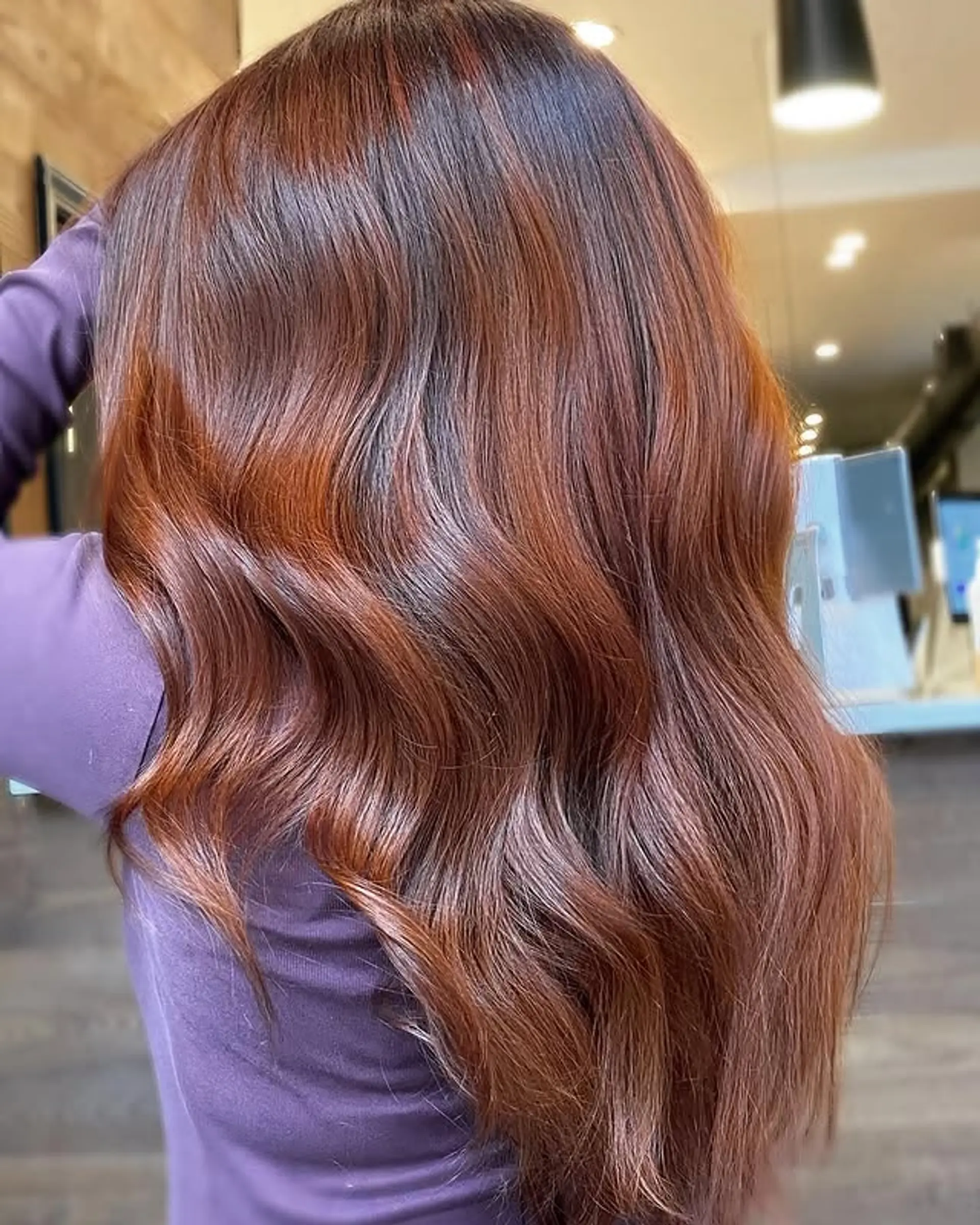 A long and wavy hairstyle with a copper balayage. 1