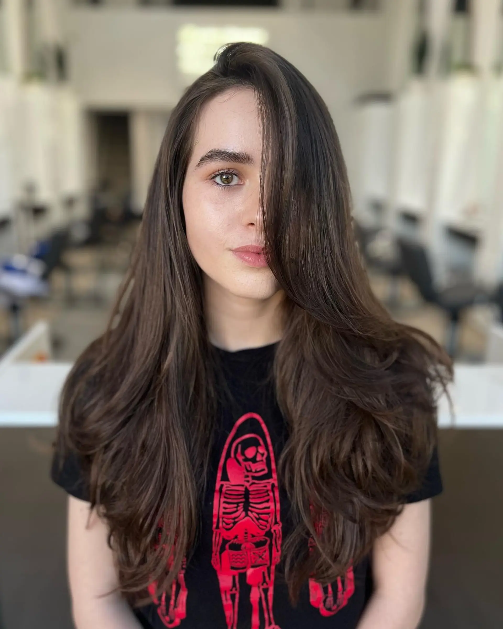 Long dark brown hair styled with voluminous face-framing layers and soft curved ends. 1