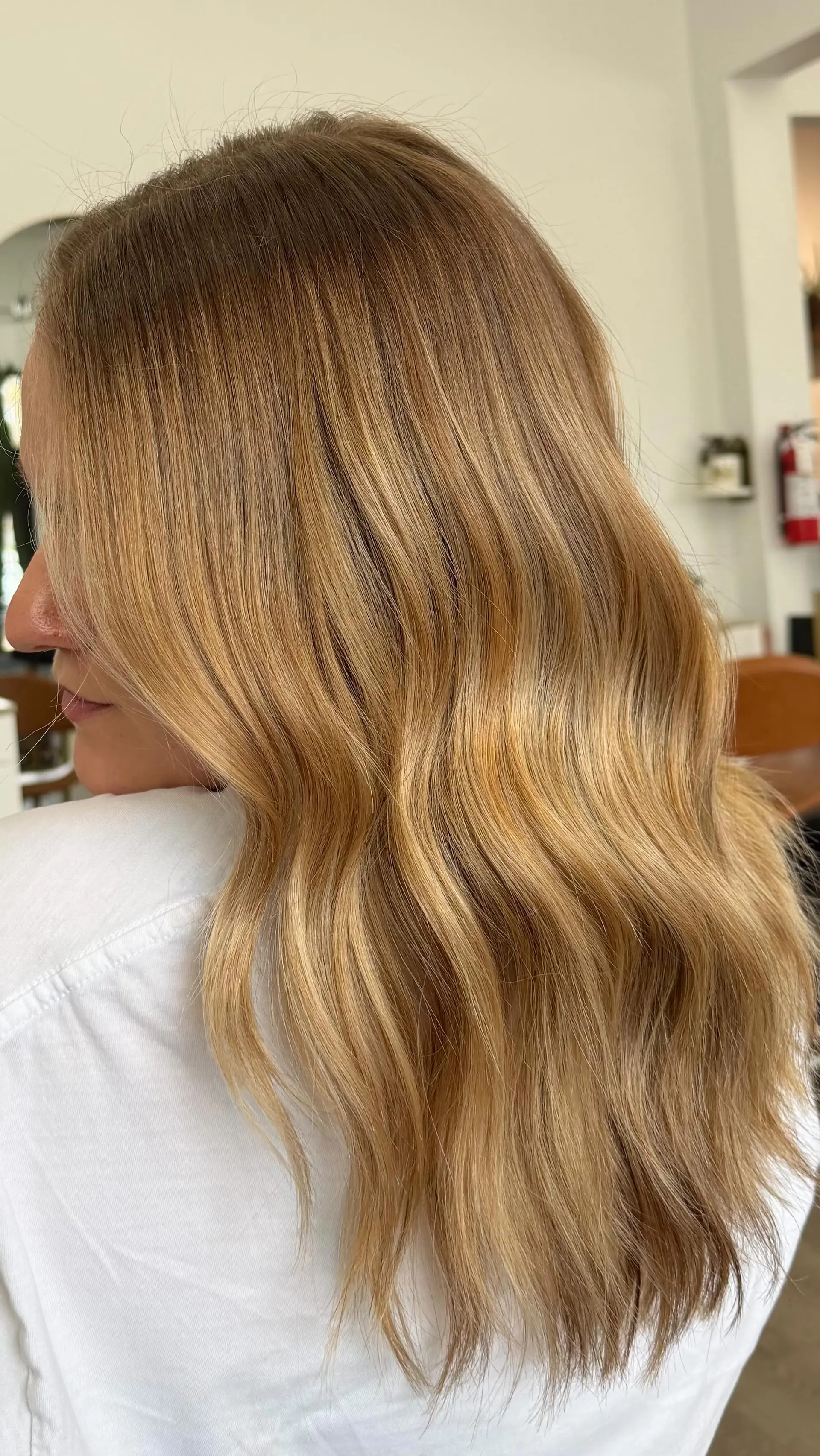 Warm golden blonde hair with dimensional highlights styled in soft, cascading waves. 1