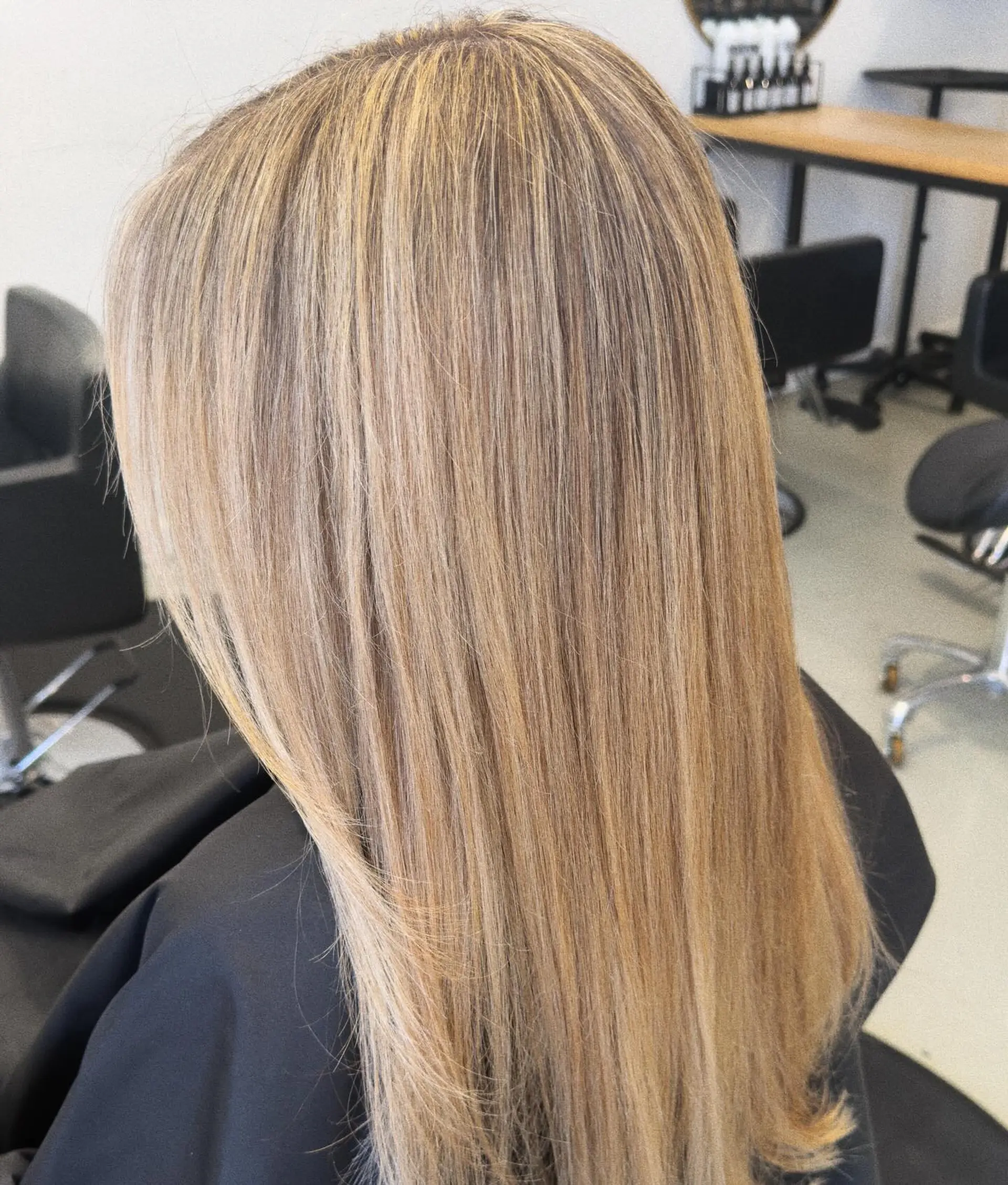 Long, sleek straight hair featuring finely blended warm and neutral blonde highlights over a light brown base. 1