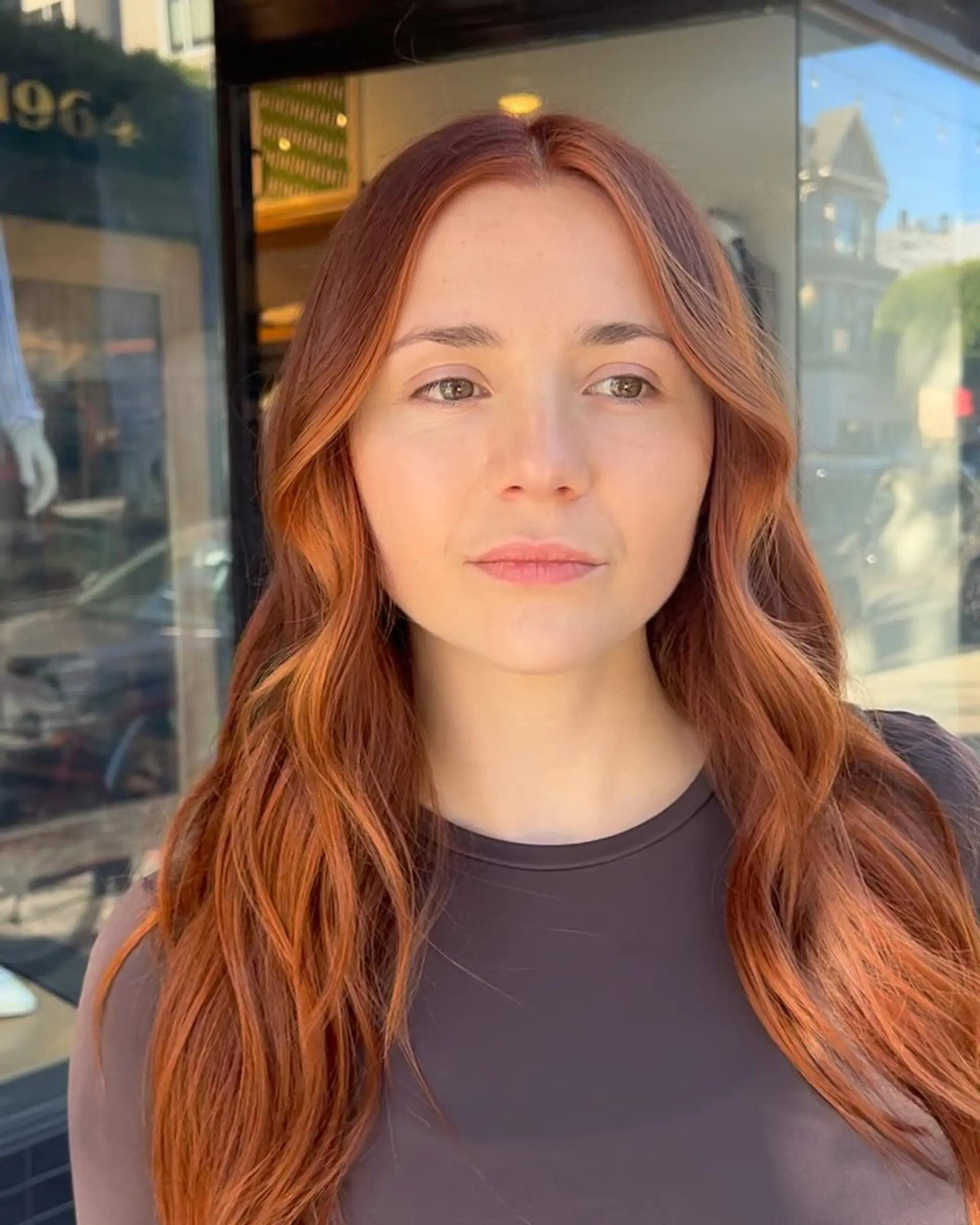 Vibrant dimensional copper hair parted in the middle and styled into soft, flowing waves. 1