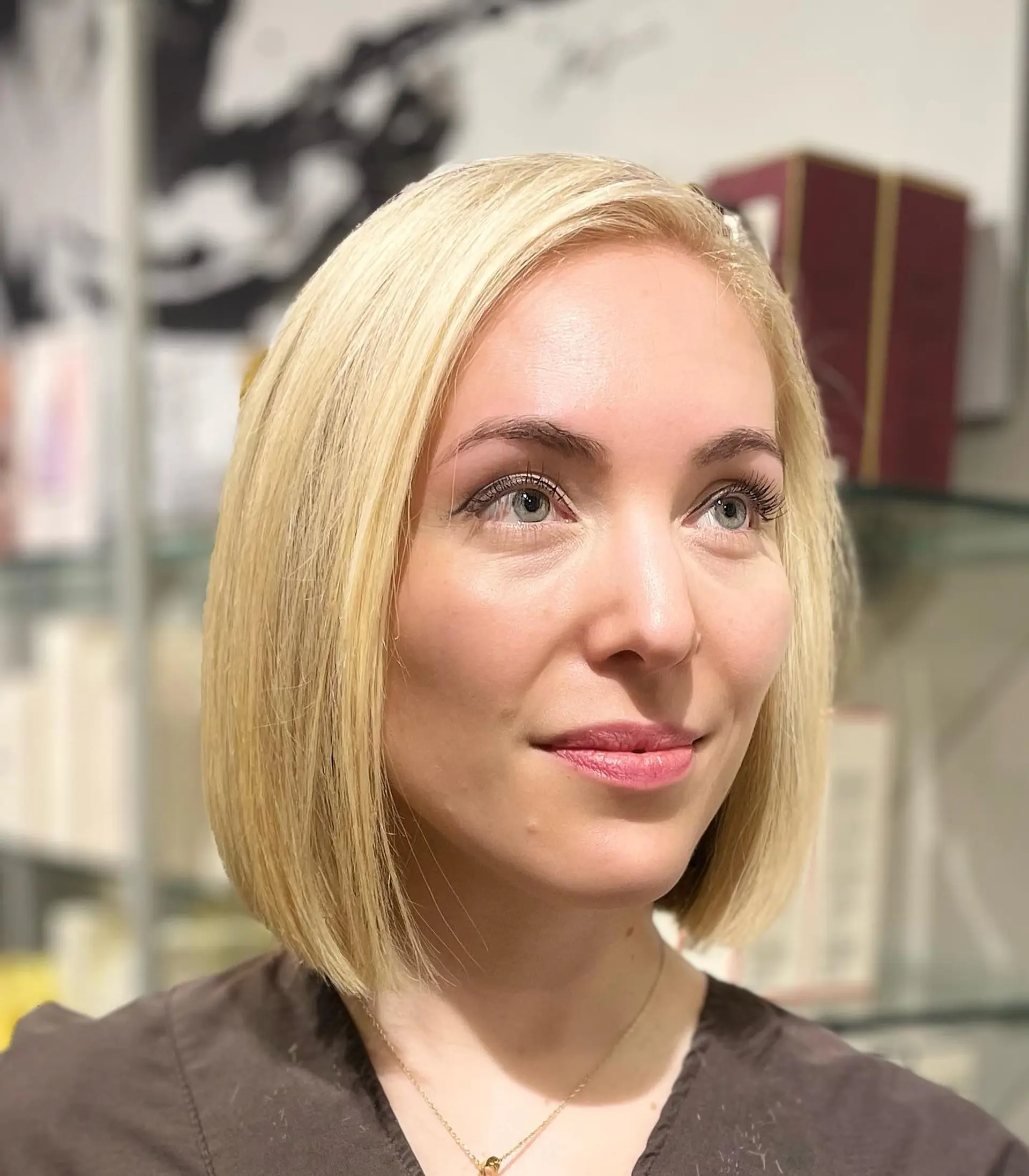A sleek, chin-length classic bob styled straight with luminous blonde highlights. 1
