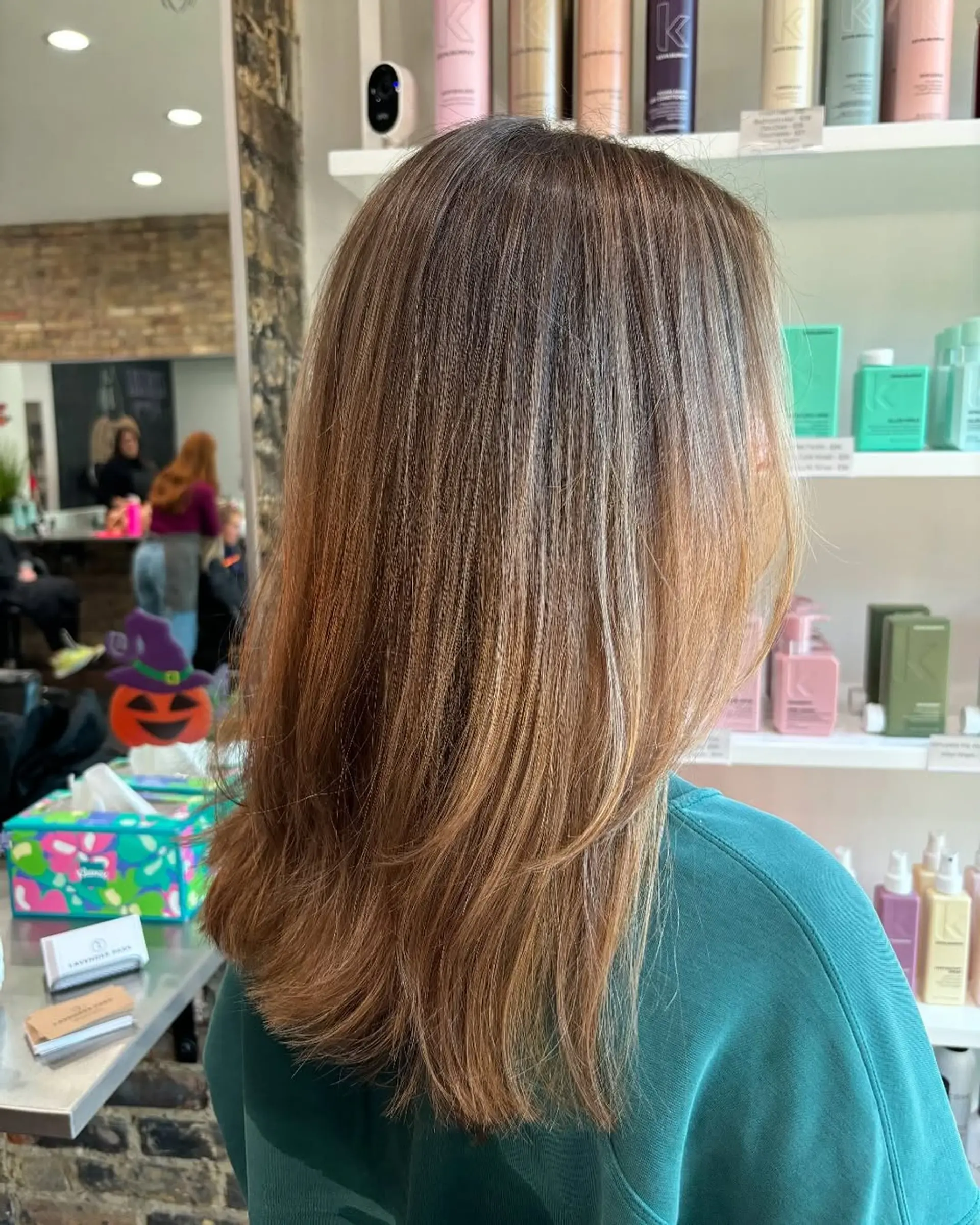 This chic style combines a medium-length layered cut with a stunning caramel bronde balayage, creating depth and movement with its seamlessly blended dimensional color. 1