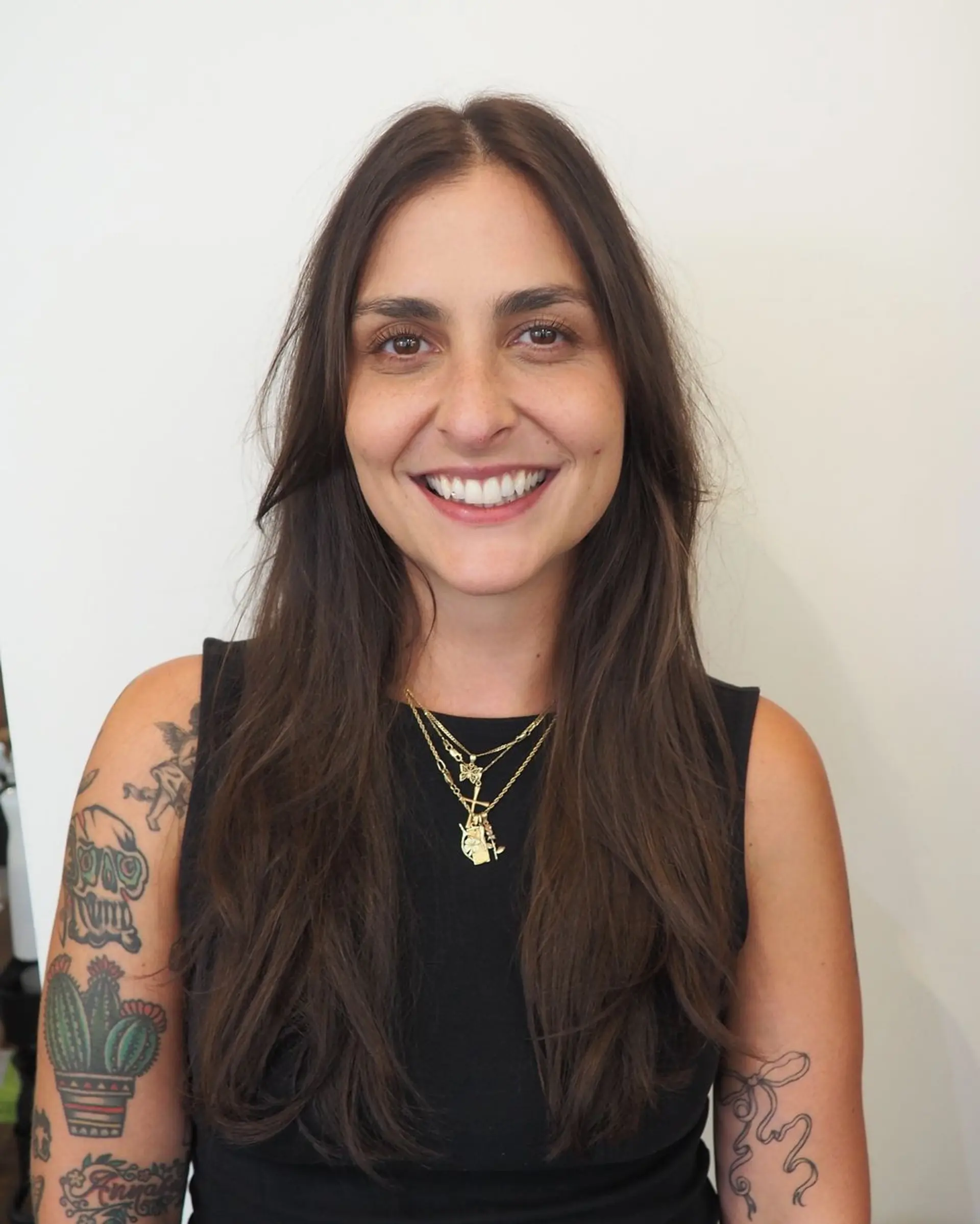 A long, straight hairstyle with a natural part and layered texture, featuring dark brown hair and soft waves for a casual, earthy vibe. 1