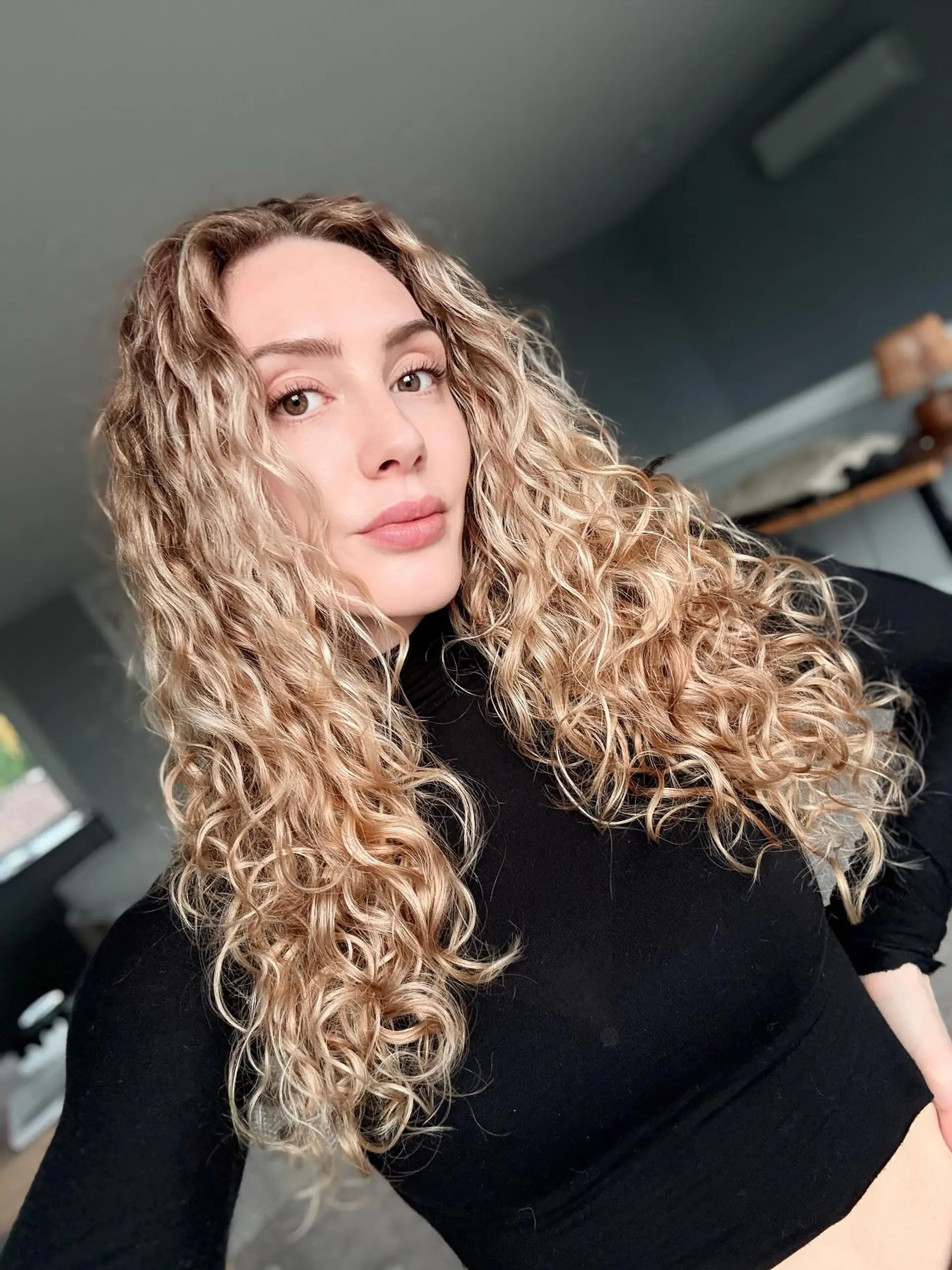 Long defined curly hair cut with shape-enhancing layers and natural volume. 1