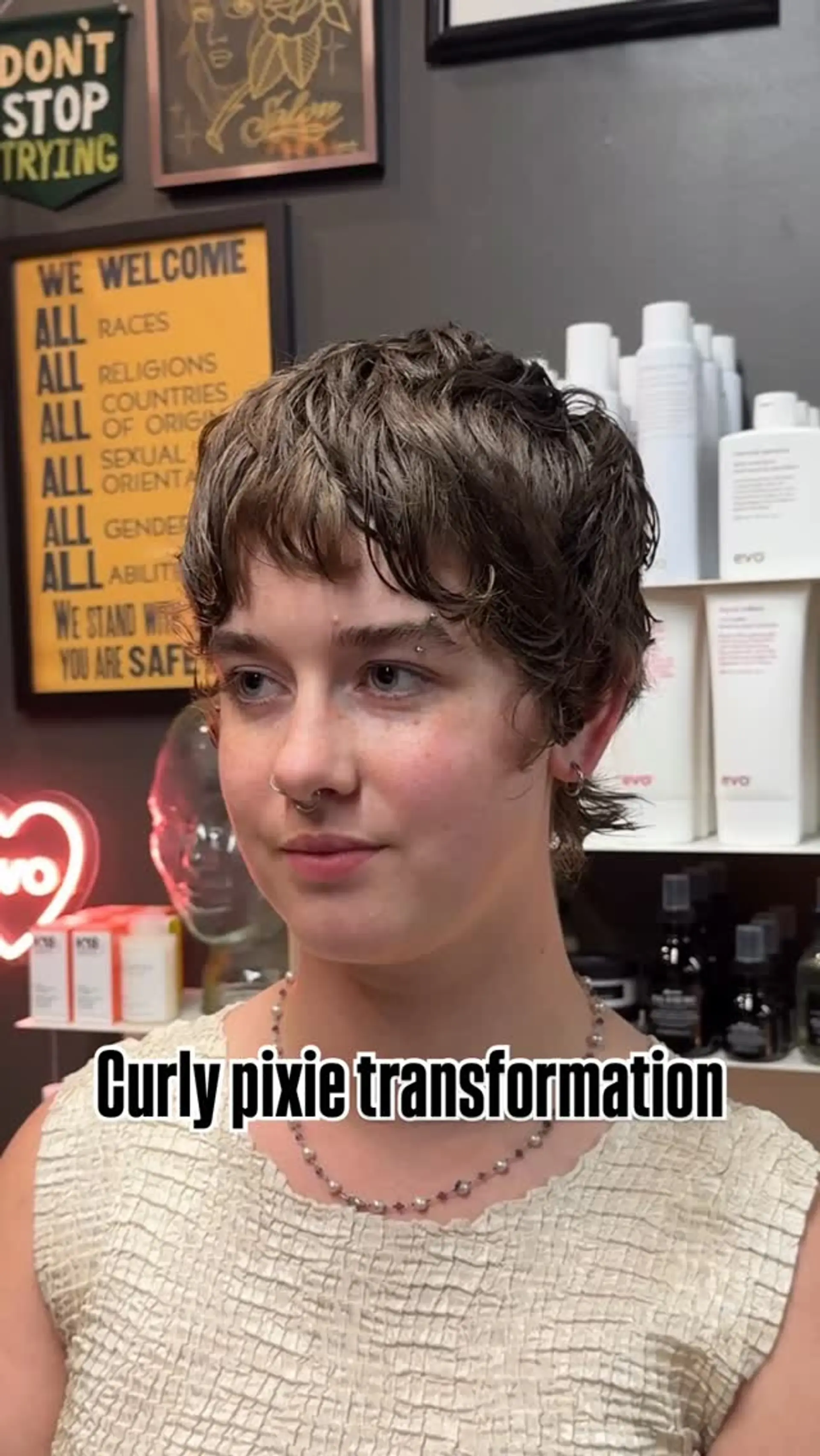 A textured curly pixie haircut with soft, piecey fringe and tapered sides. 1