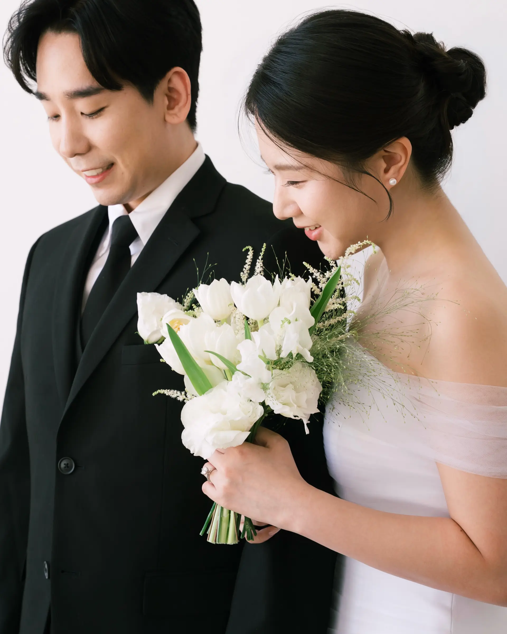 A sleek, elegant bridal updo with soft tendrils paired alongside clean, classic groom styling. 1
