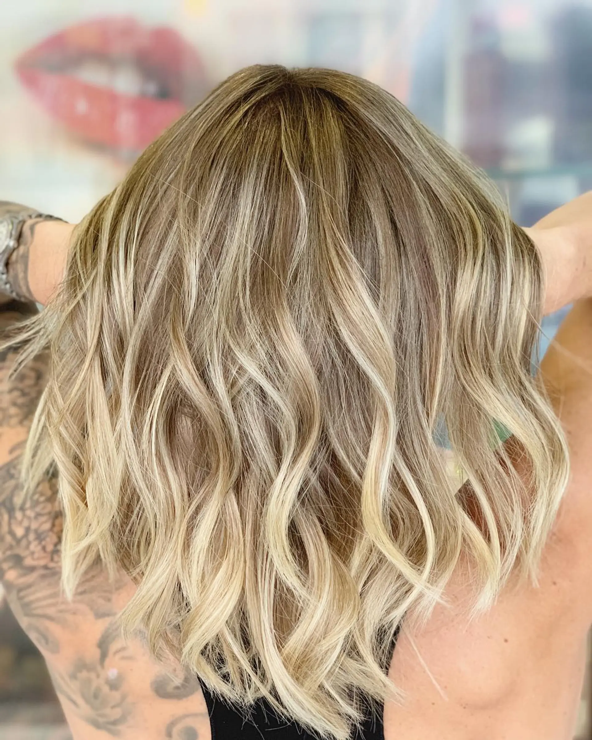 A wavy, medium-length lob (long bob) with a beachy blonde balayage. 1