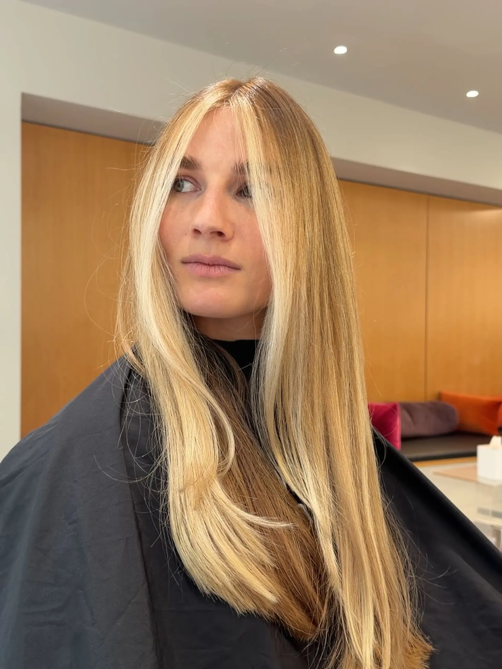 Long straight hair highlighted with a prominent bright blonde face-framing money piece. 1