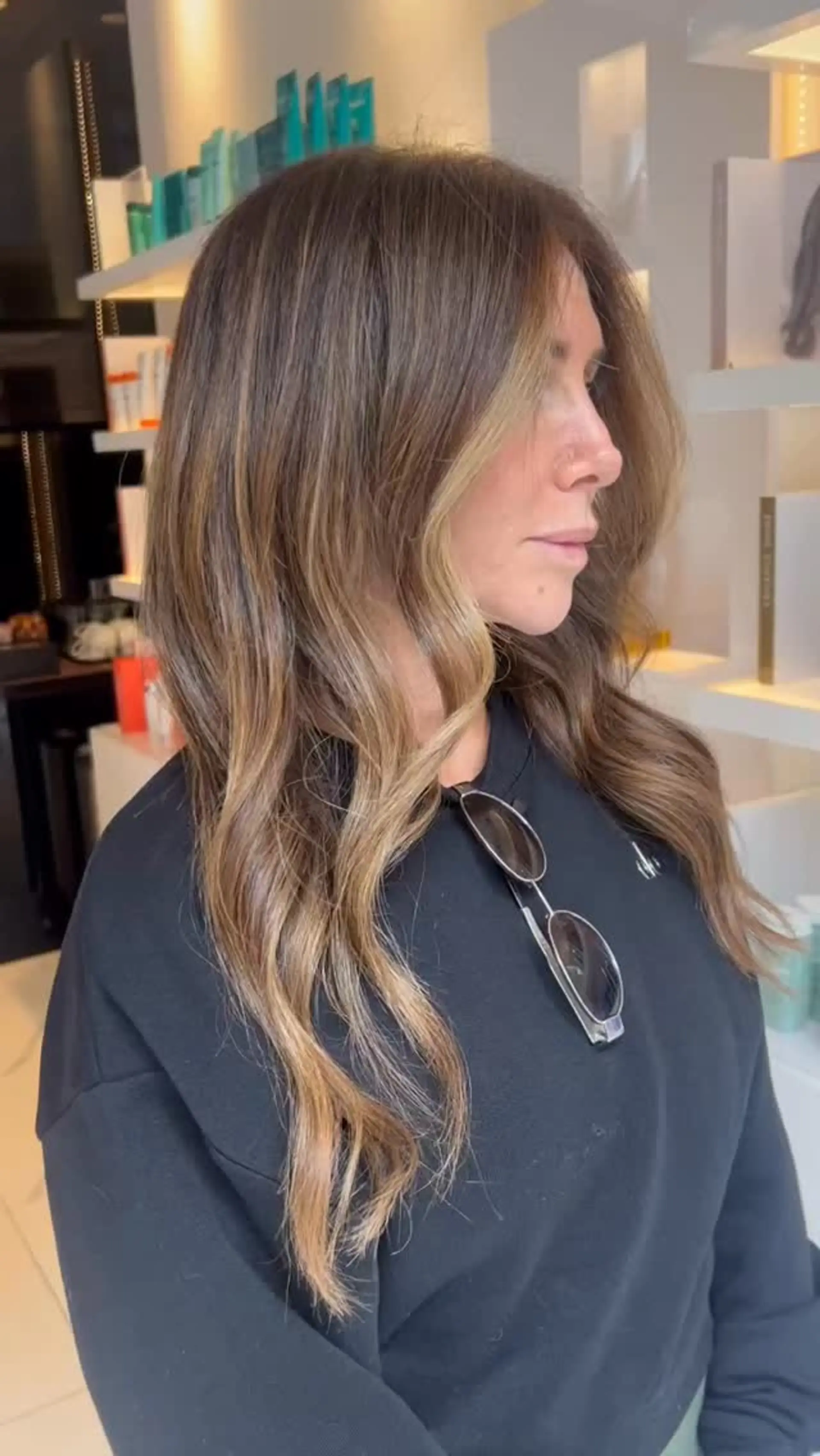 Long layered brunette hair with a soft root melt, warm caramel balayage, and loose waves. 1