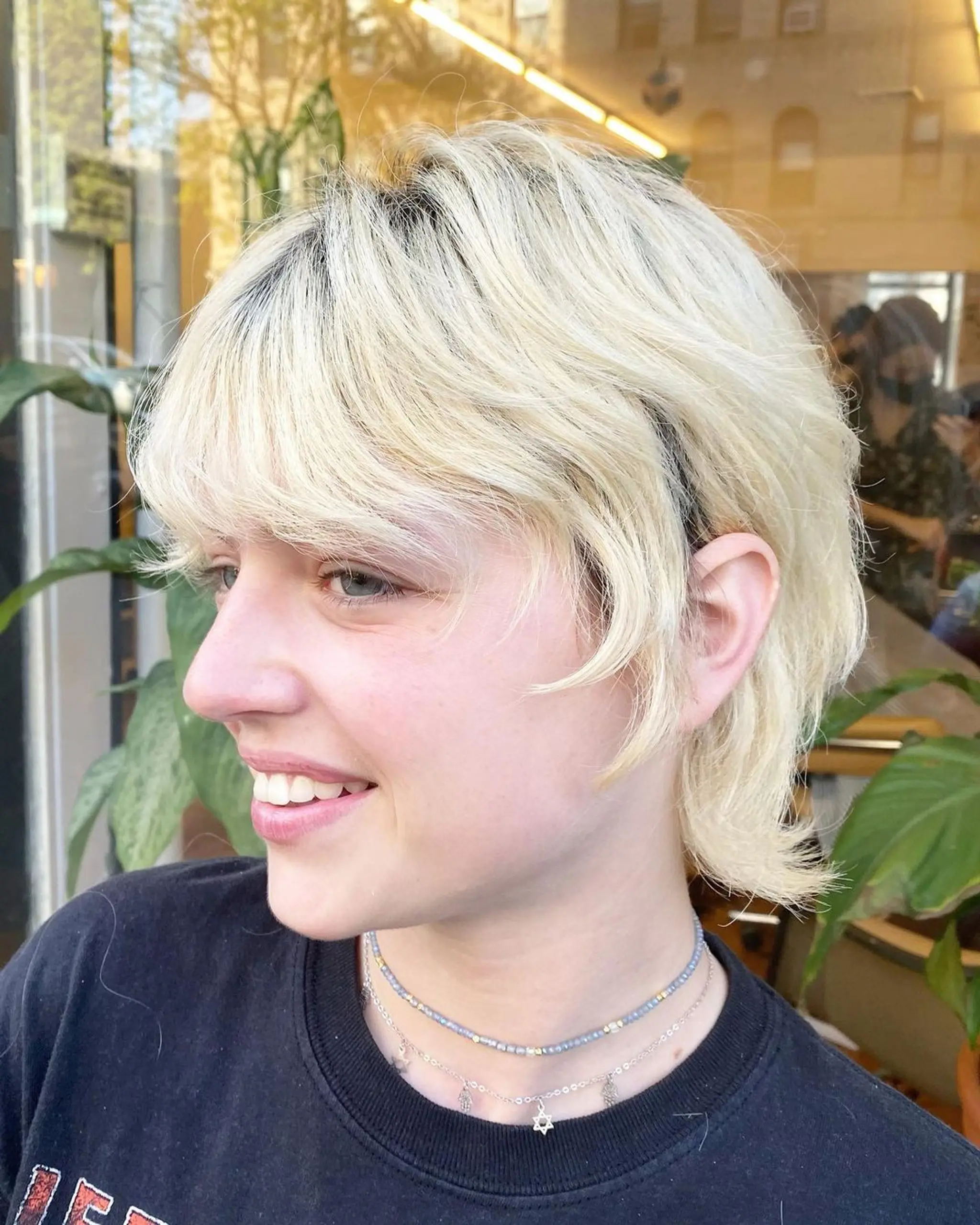 Soft, textured layers with a platinum blonde color, natural waves, and a side-swept fringe, creating a chic and modern look. 2