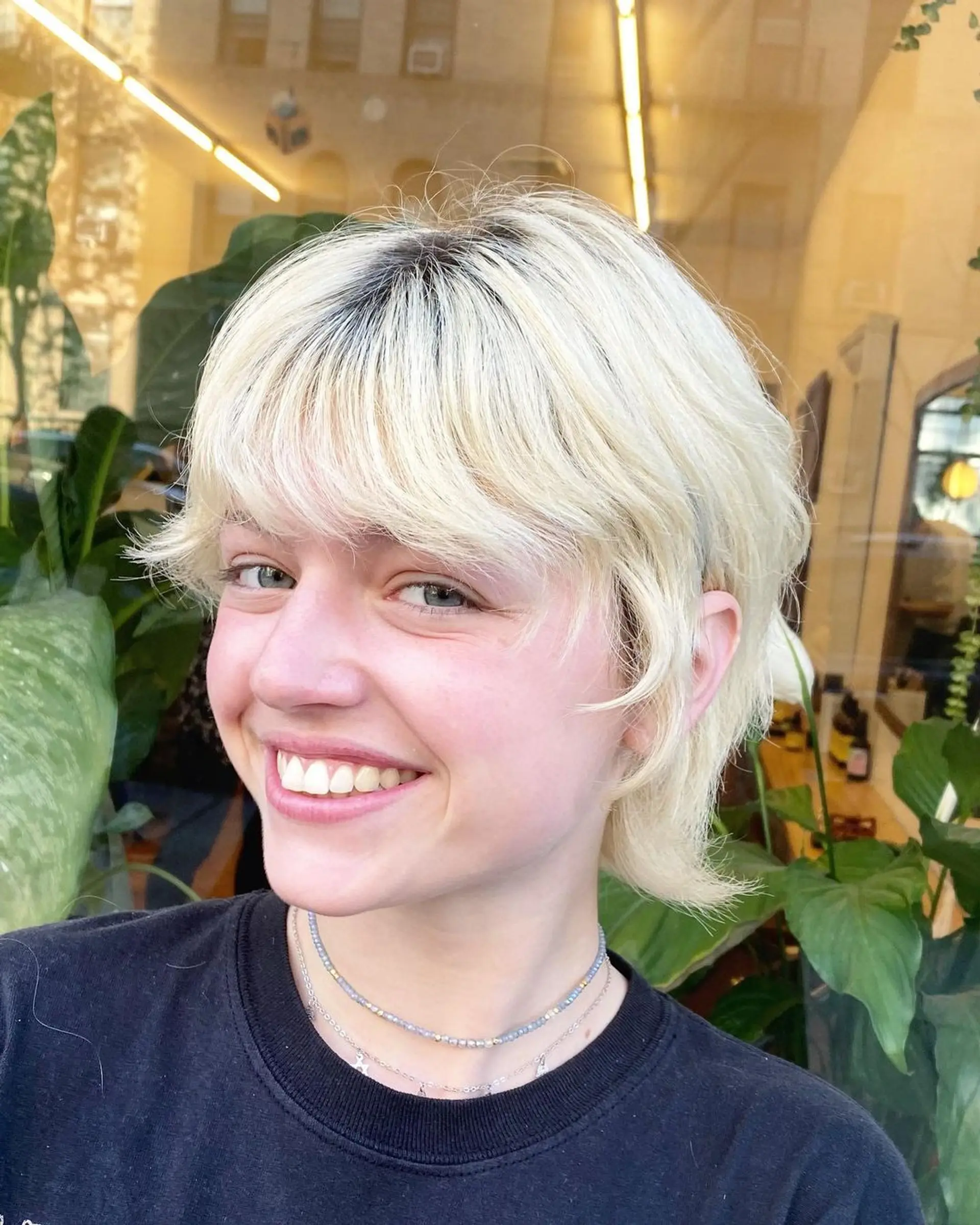 Soft, textured layers with a platinum blonde color, natural waves, and a side-swept fringe, creating a chic and modern look. 1