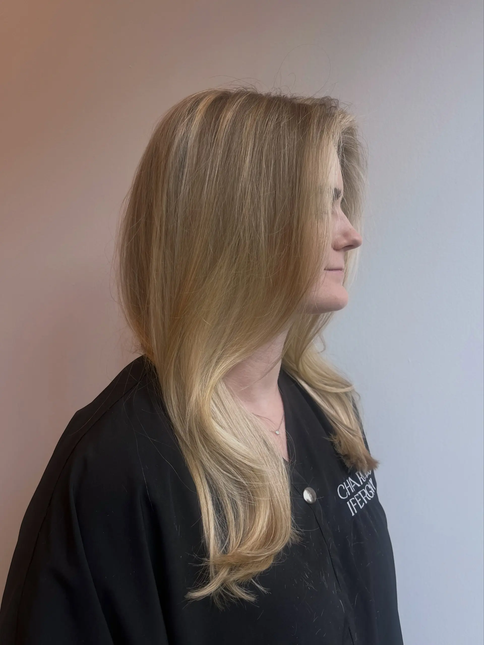 Smooth, warm blonde blowout featuring soft face-framing layers and subtly curved ends. 1