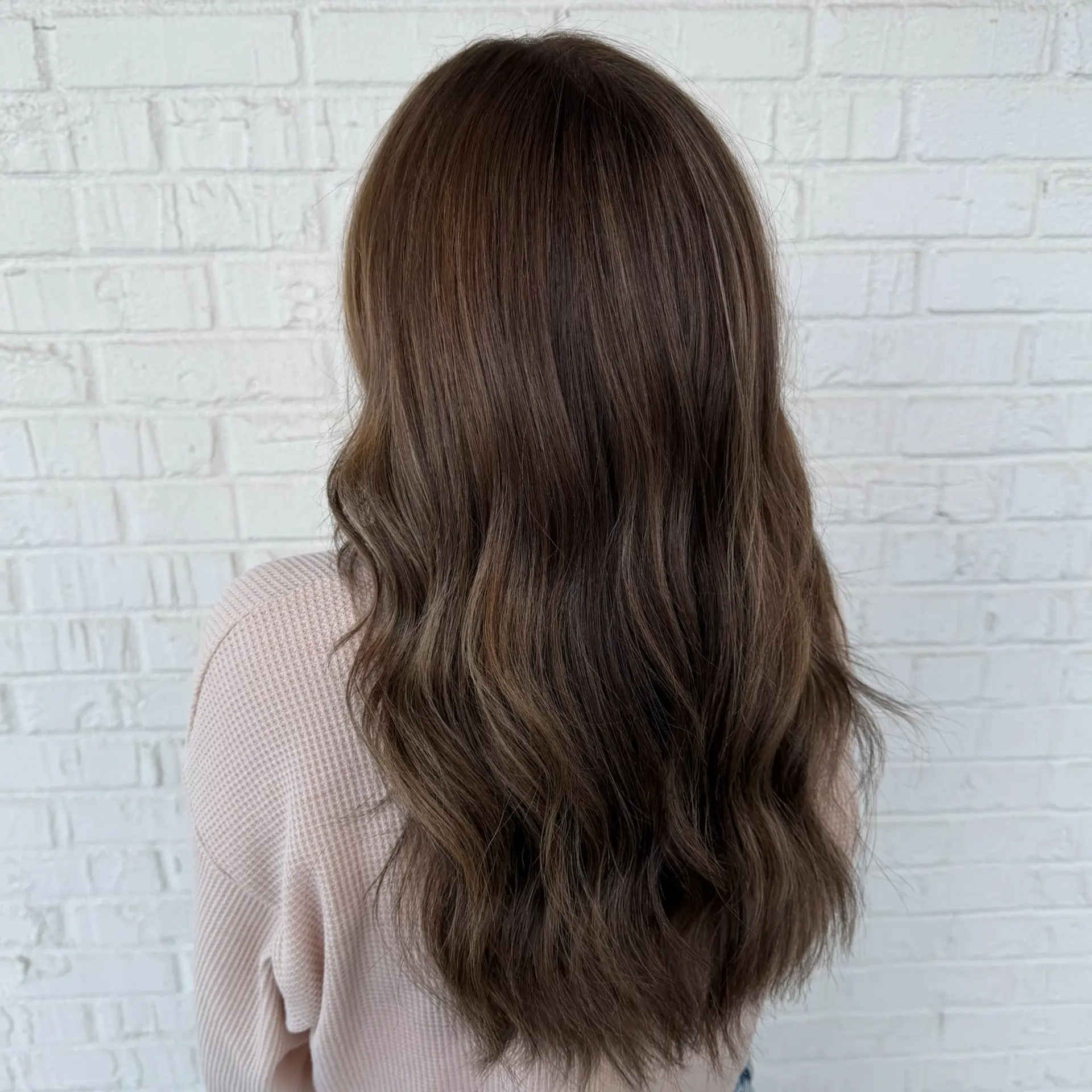 Long, dimensional hot cocoa brunette hair styled with loose, relaxed waves. 1