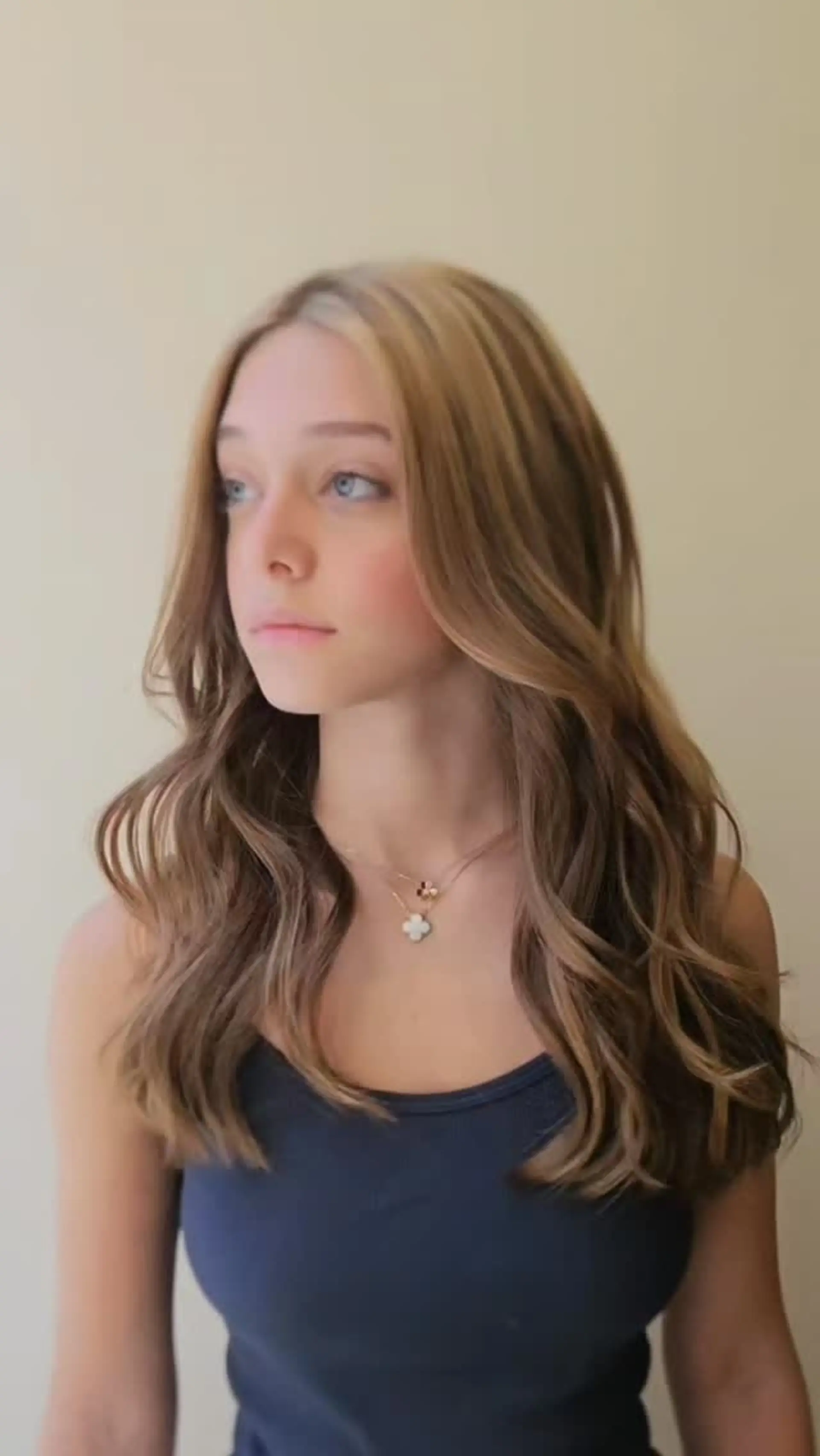 Long layered hair styled into voluminous, loose blowout waves with face-framing pieces and soft dimension. 1
