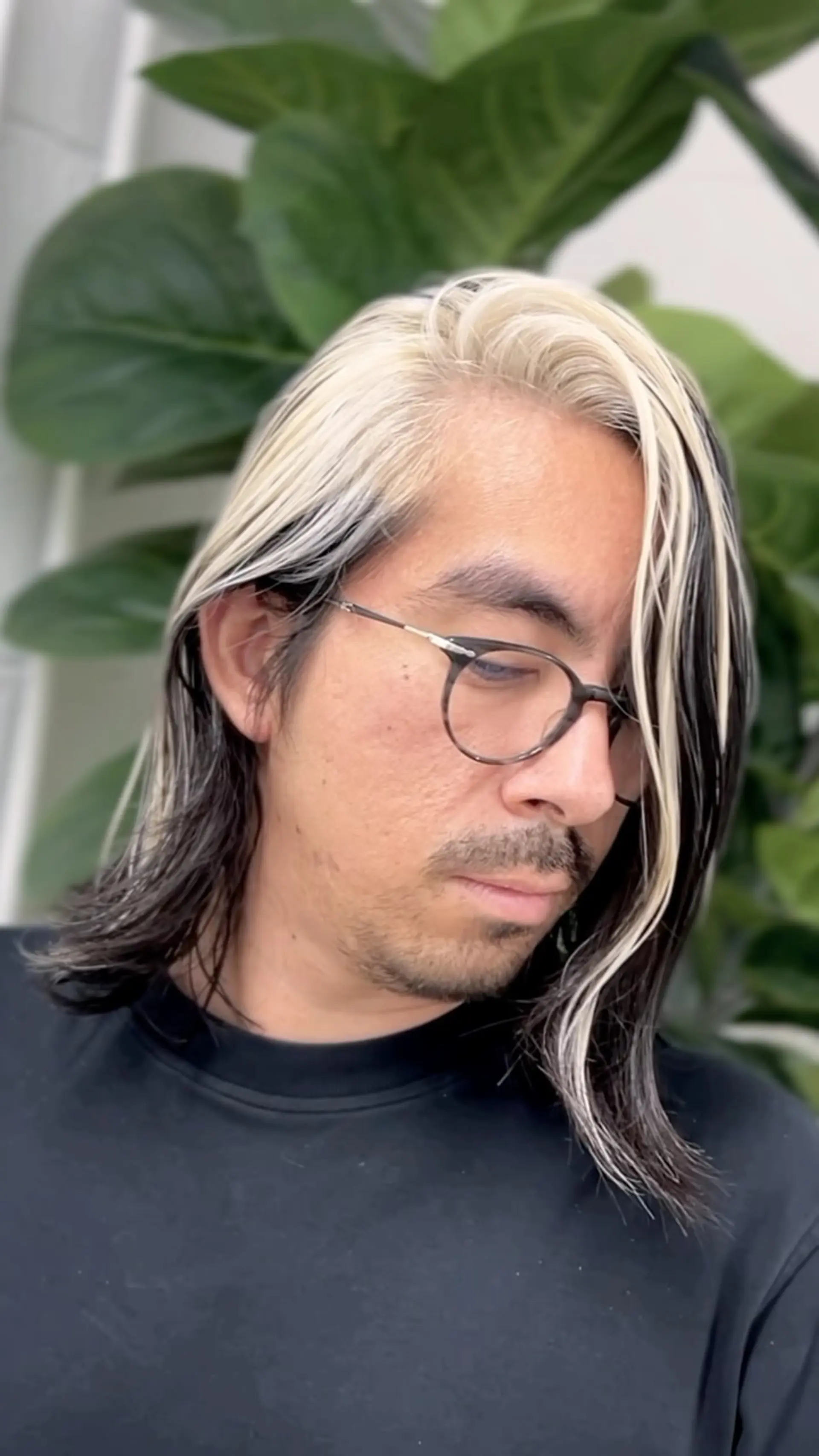 Medium-length dark hair featuring a bold platinum blonde face-framing block accentuating one side. 1