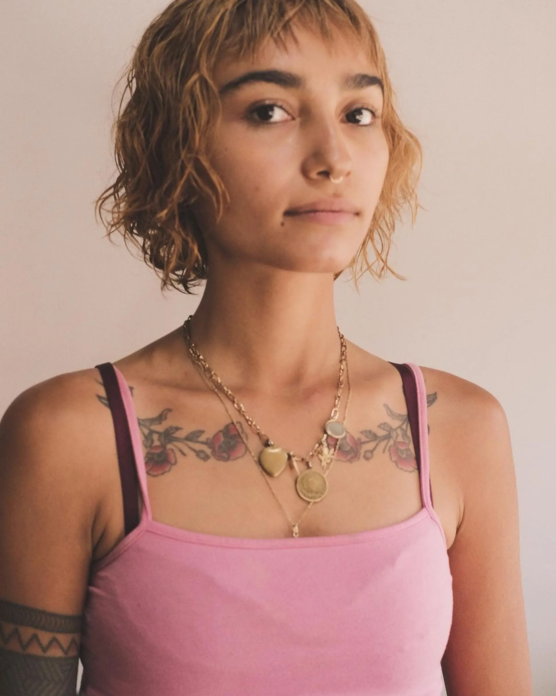 A short, wavy cut with textured fringe, tousled waves, and a beachy vibe. The hair sports blonde and light brown hues, styled in a messy, layered fashion. 2