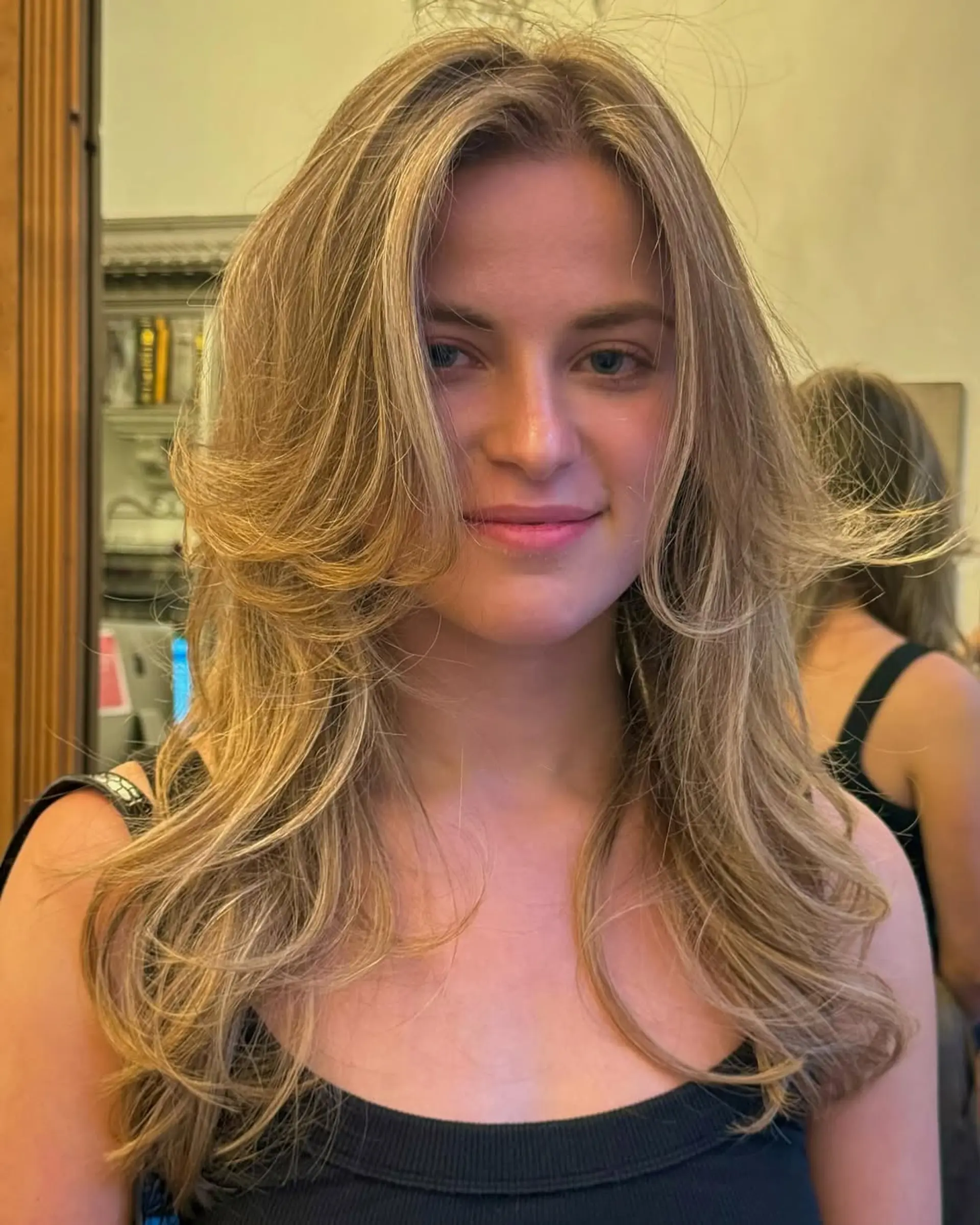 Long, golden blonde, softly layered waves with a radiant shine and natural flow. 4