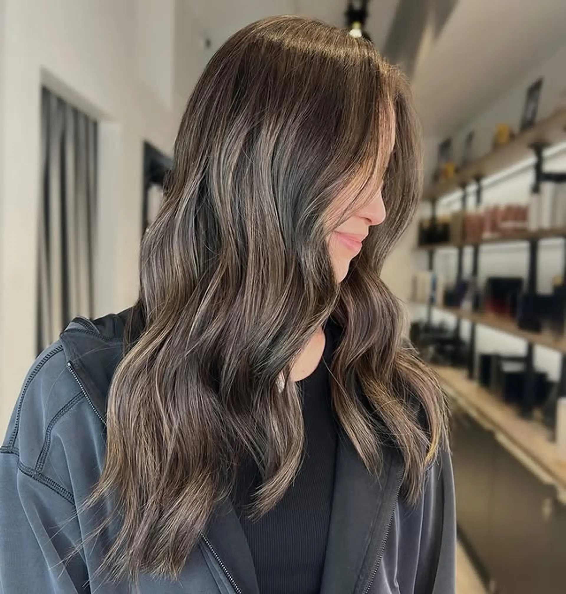A long, wavy style with a bronzed ash brown balayage and subtle waves. 1