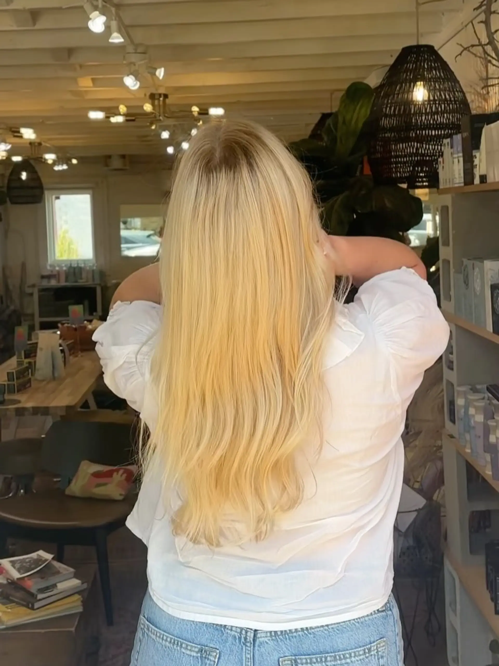 Long warm blonde hair featuring seamless dimensional highlights styled smooth down the back. 1