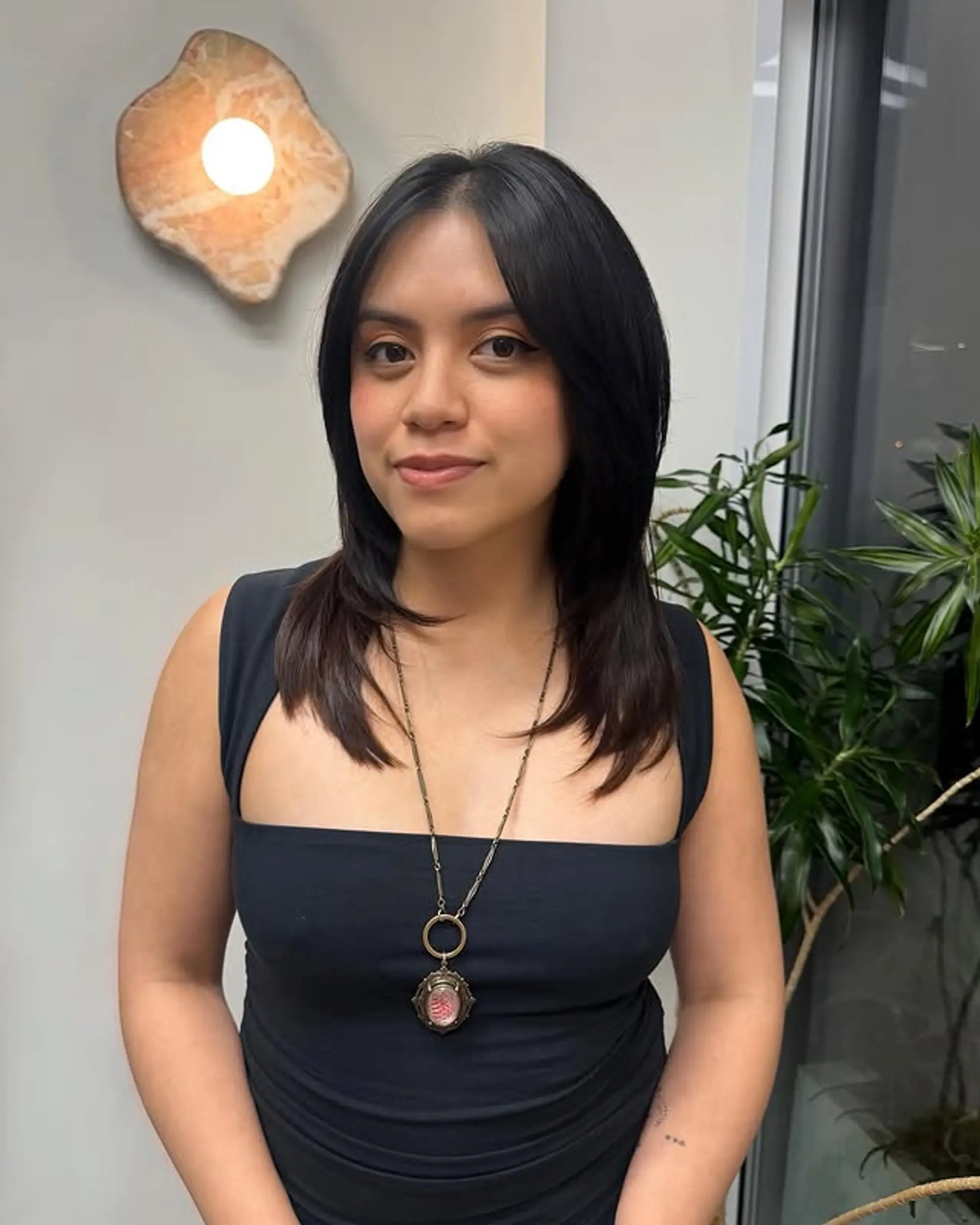 A medium-length haircut with layered curtain bangs and face-framing layers. 1