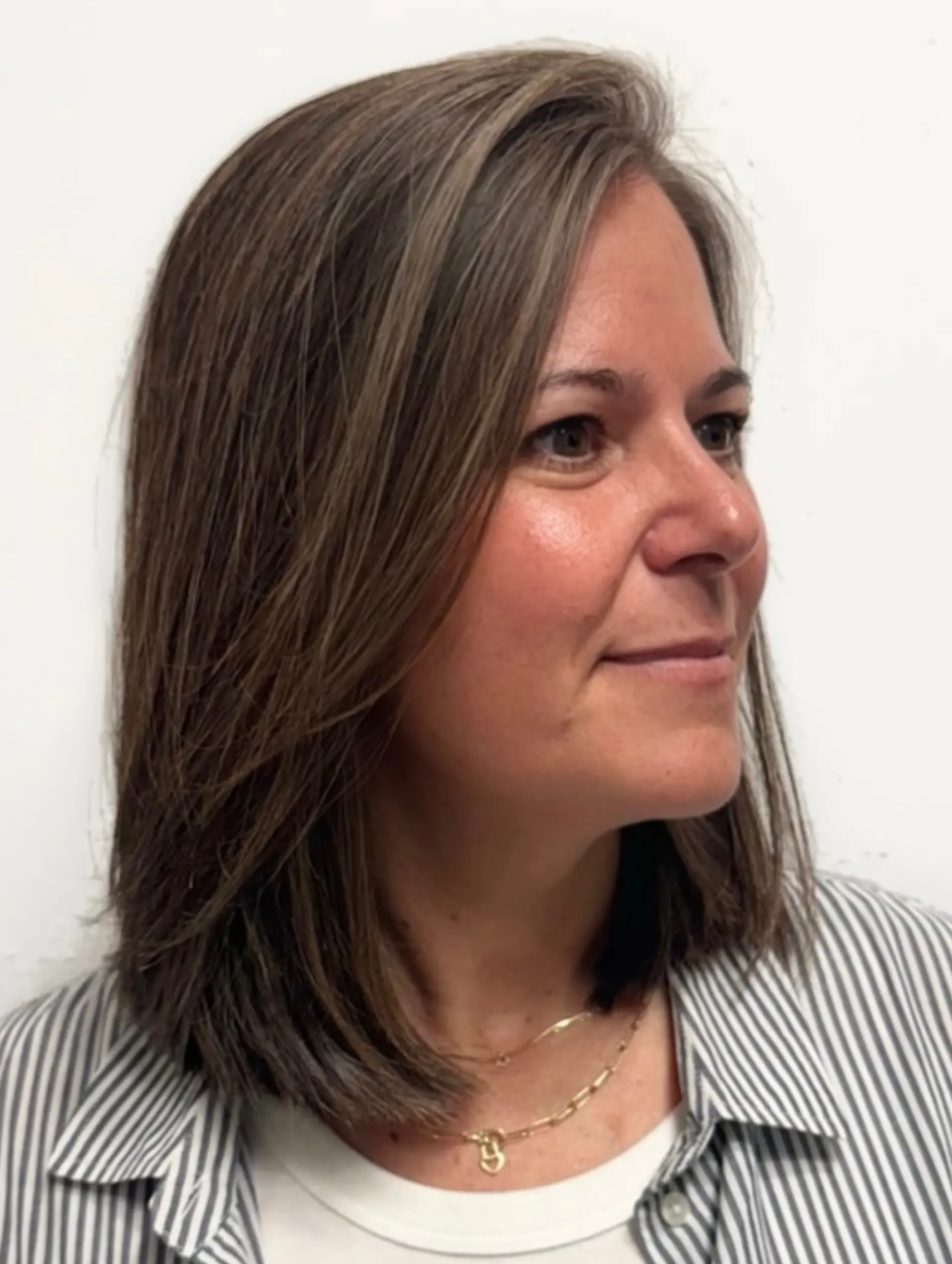 A sleek shoulder-length lob featuring soft gray blending and fine babylights. 1