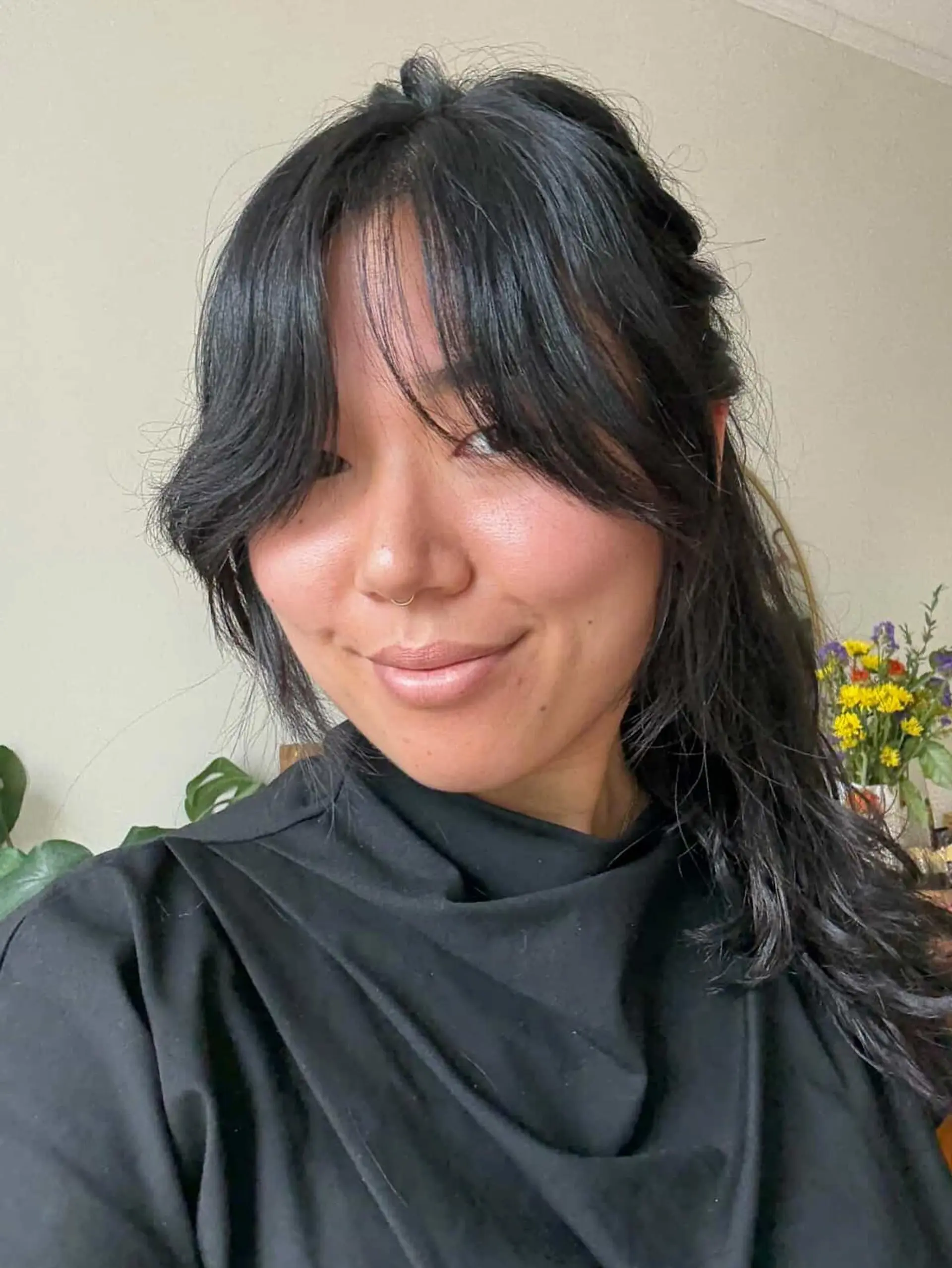 Dark hair styled with soft, face-framing curtain bangs and wispy fringe pieces. 1