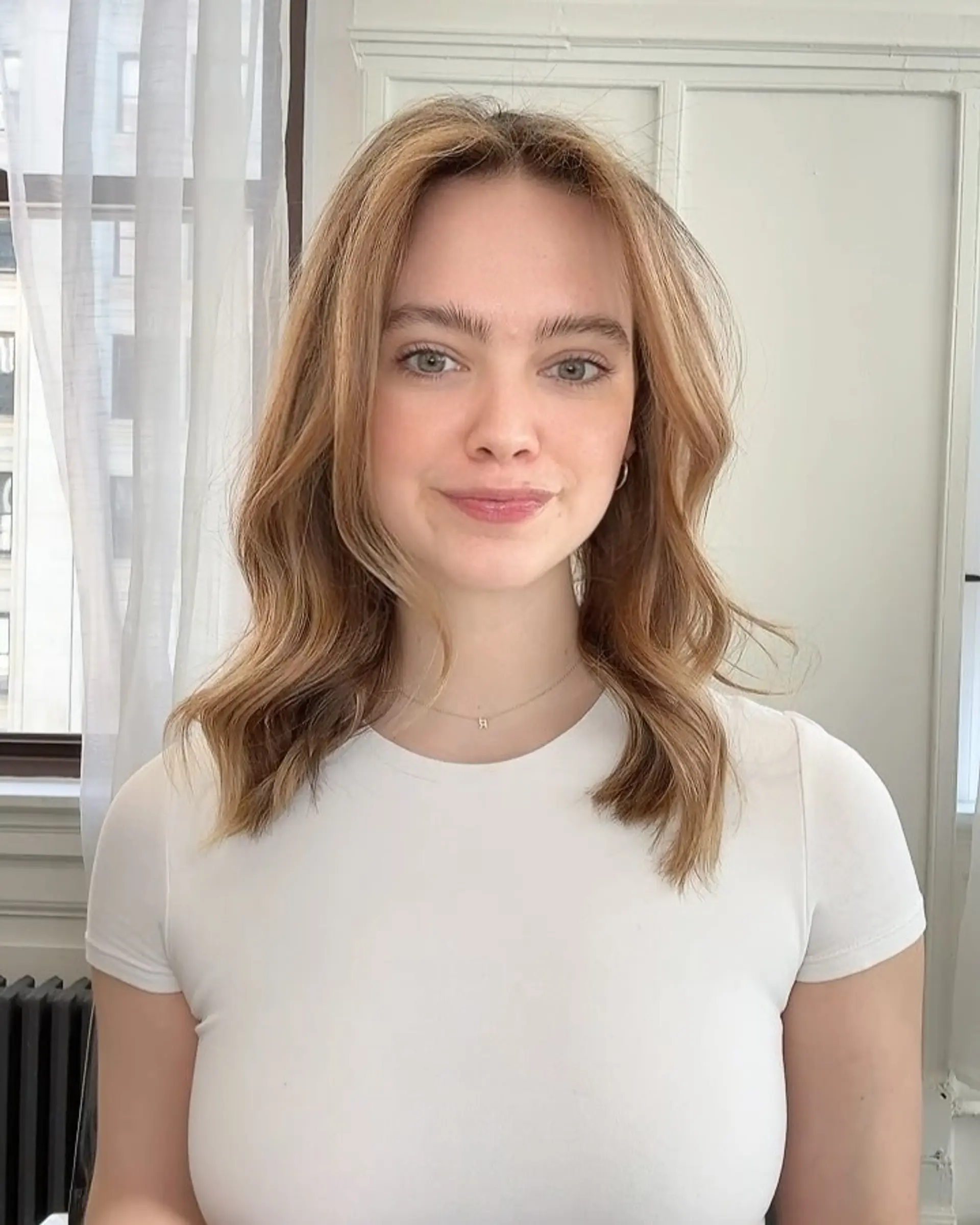 Collarbone-length lob styled in soft, loose waves featuring a seamless bronde balayage. 1