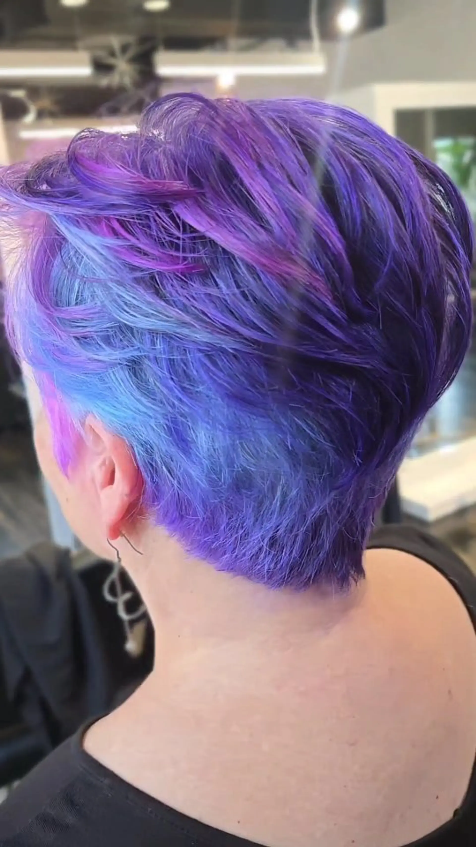 A textured short pixie cut featuring multi-tonal vivid coloring in shades of royal purple, electric blue, and magenta. 1