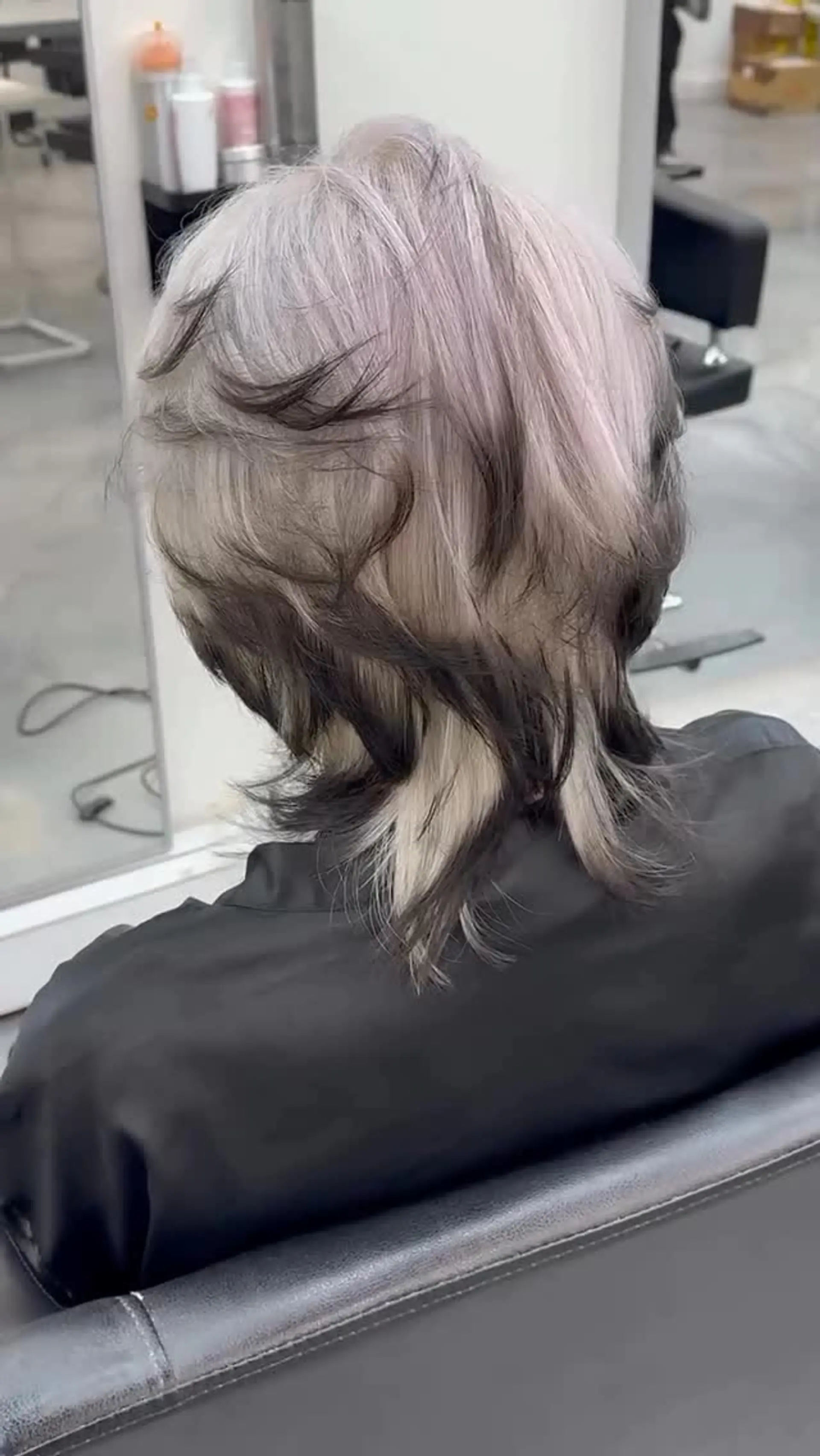 A textured layered mullet with an icy platinum blonde base accented by black dip-dyed tips. 1