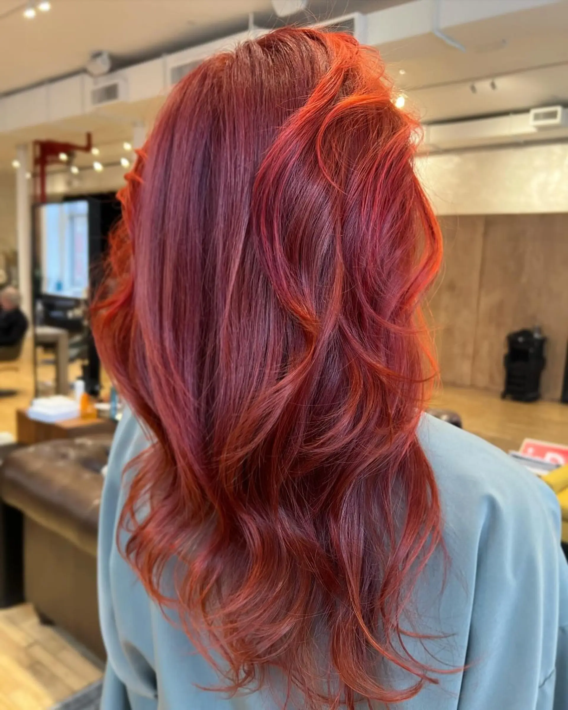 This hairstyle features radiant, fiery red and orange hues in long, wavy layers, creating a bold and dynamic look.

Stylist: @danieldoeshair 1