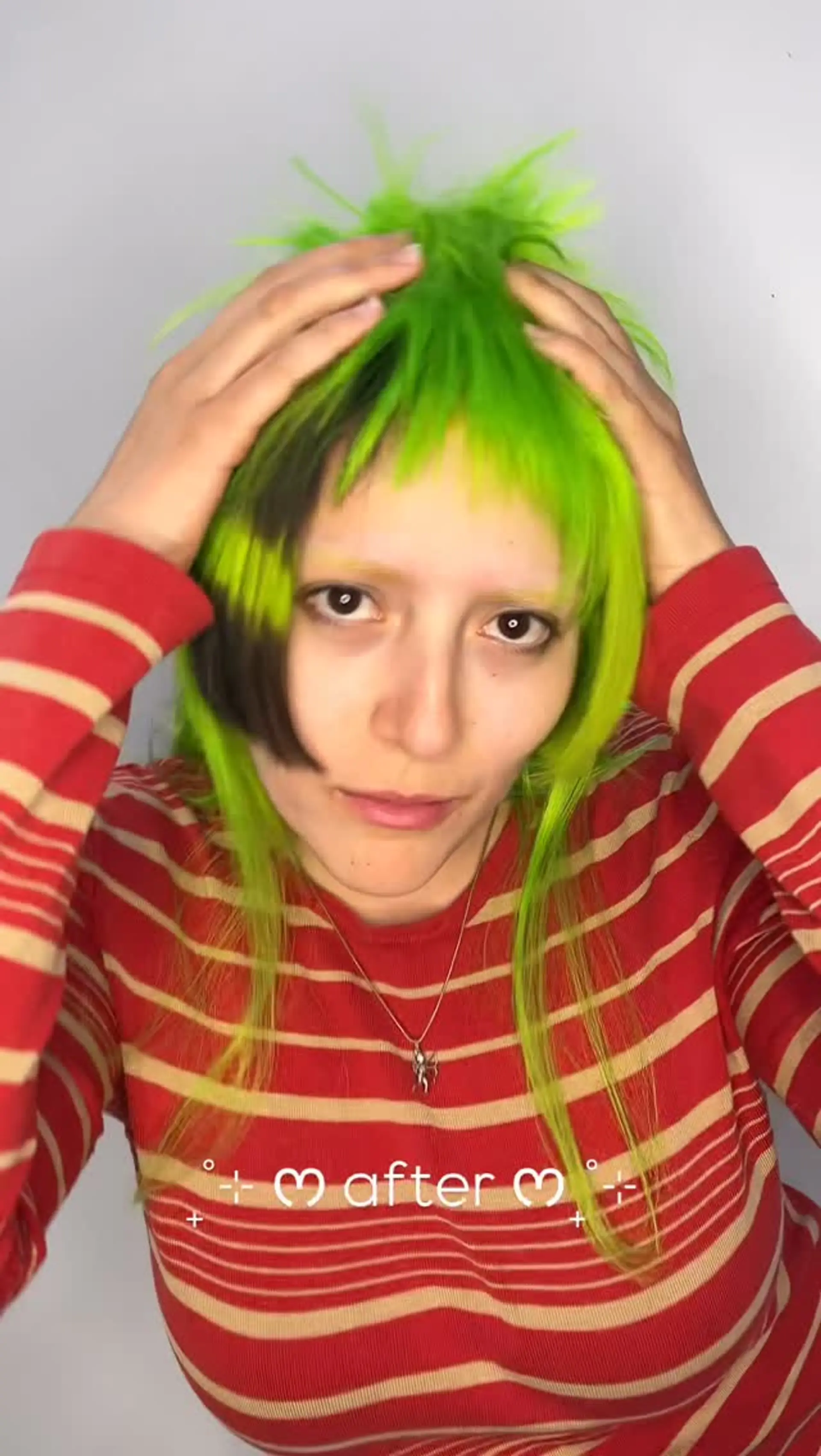Textured vivid neon green shag featuring blunt micro bangs and a contrasting dark section framing the face. 1