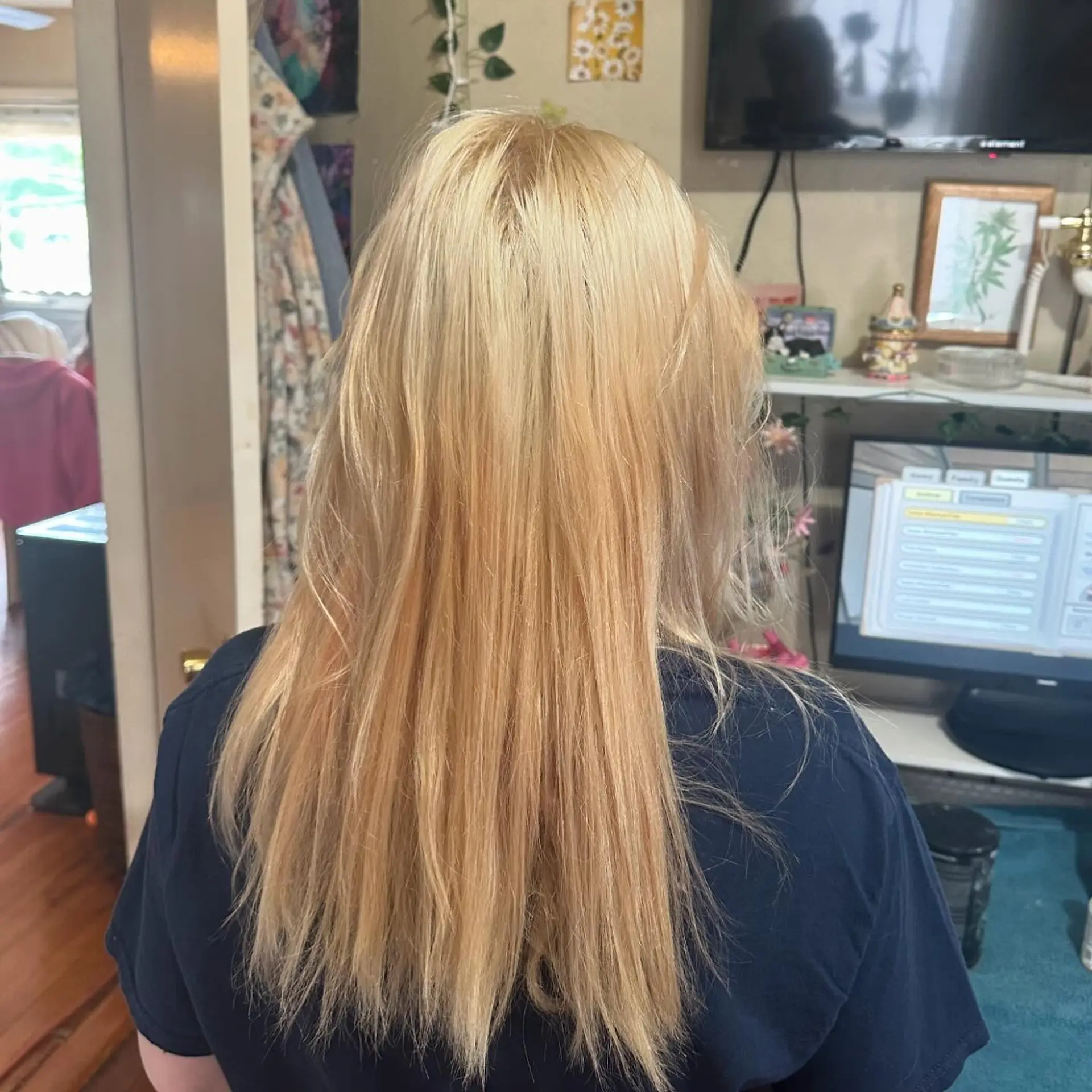 Long golden blonde hair cut straight with softly textured, wispy ends falling mid-back. 1