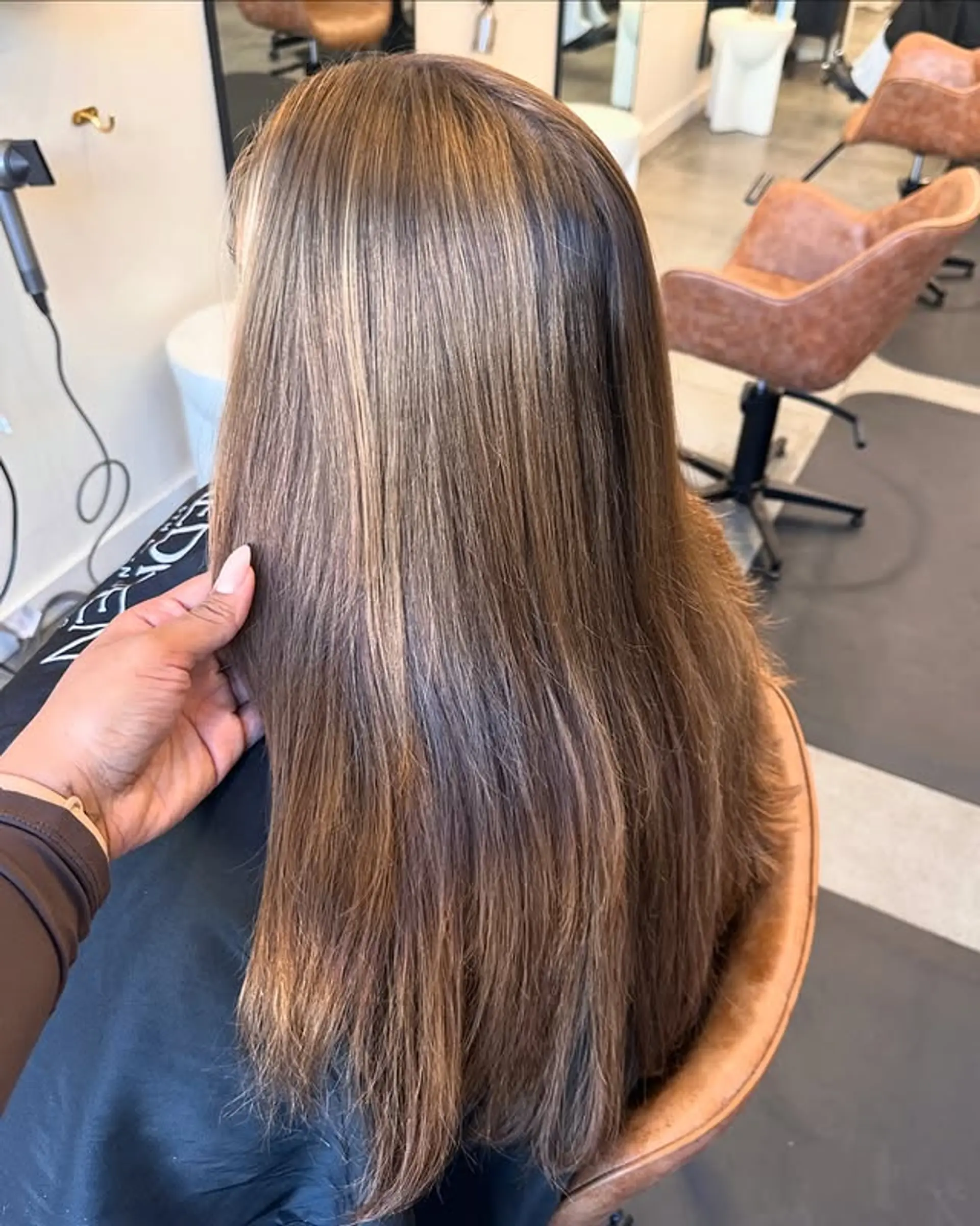 Long, straight hair with a bronzed balayage and subtle blonde highlights. 1